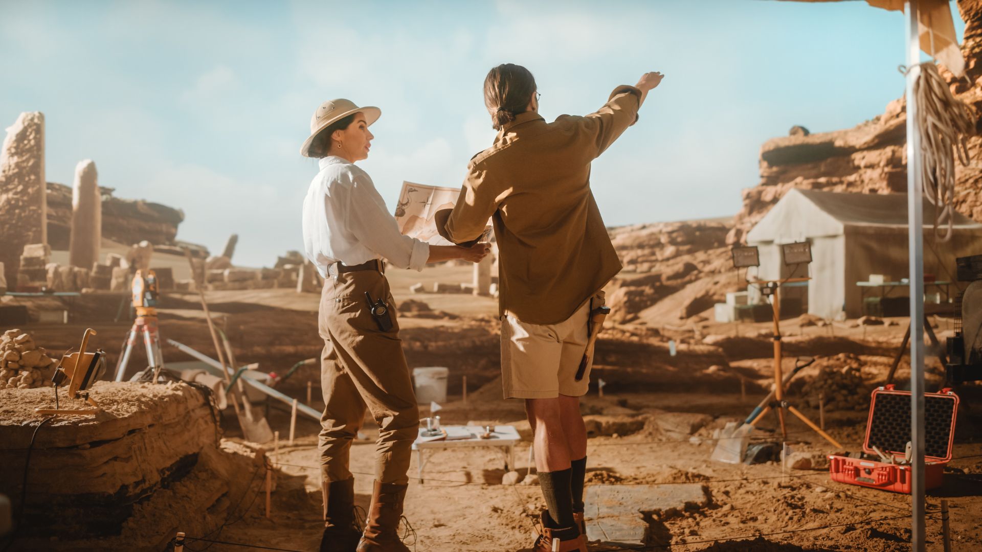 Archaeologists working at an outdoor dig site with tools and exposed stone structures