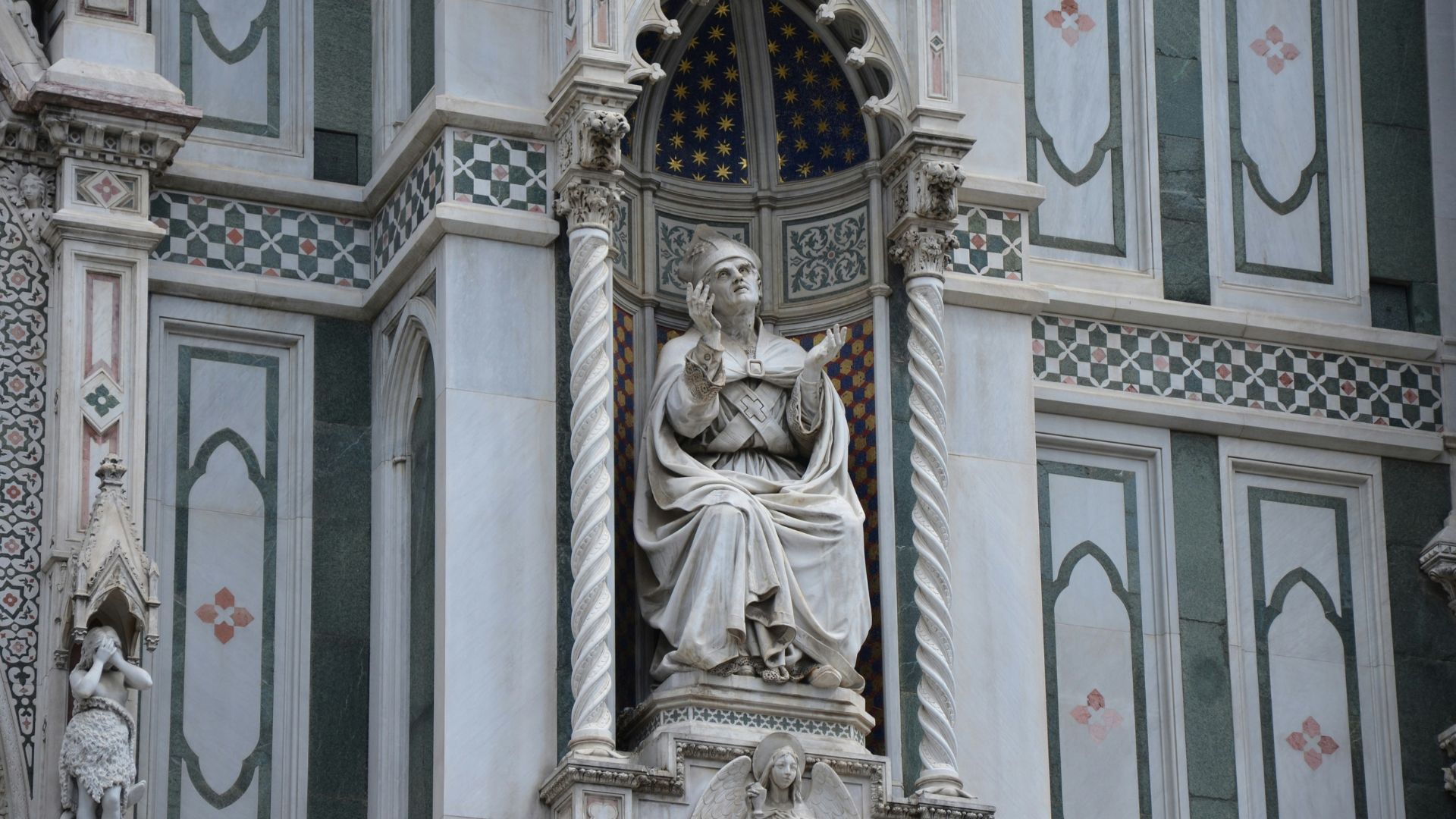 Stone statue of a woman placed on the exterior of a government-style building