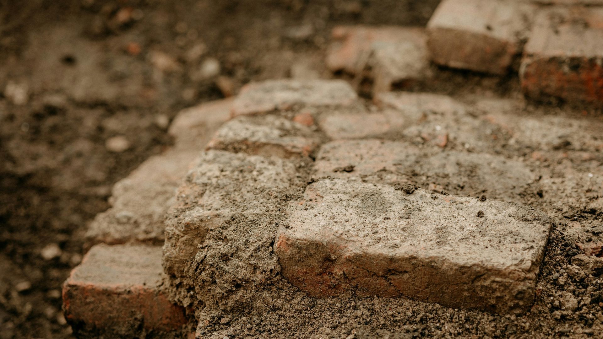 Archaeological dig site showing close-up of a brick in soil
