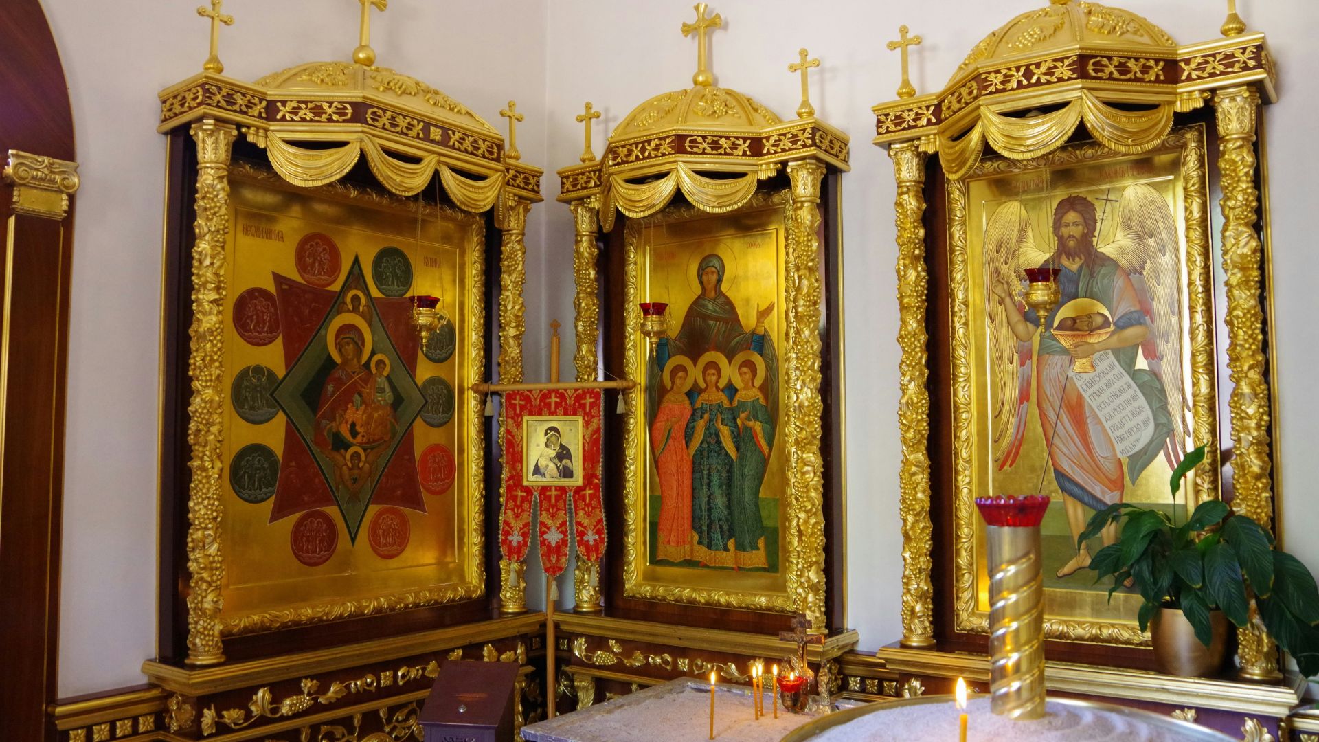 Interior of a church showing two ornate altars with paintings and gold detailing