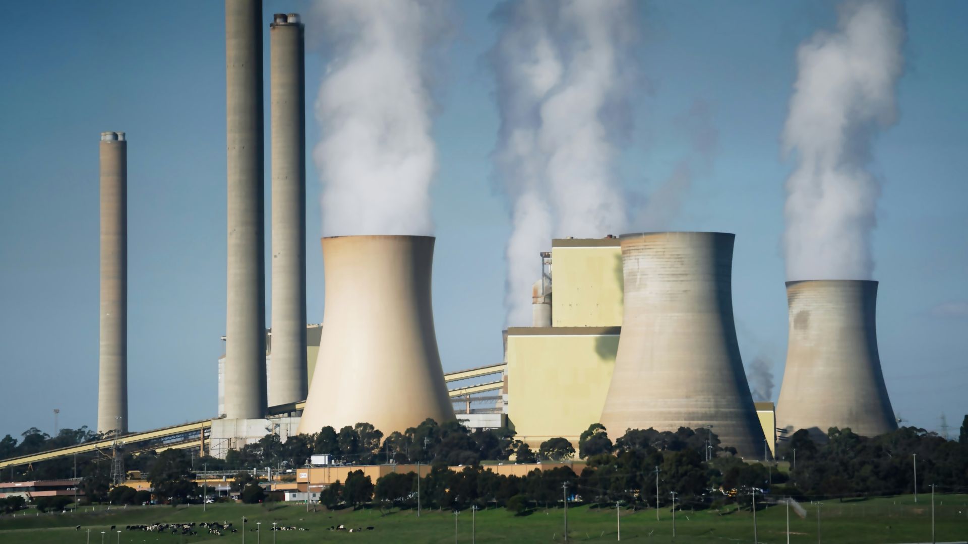 Large cooling towers at a power plant emitting thick smoke