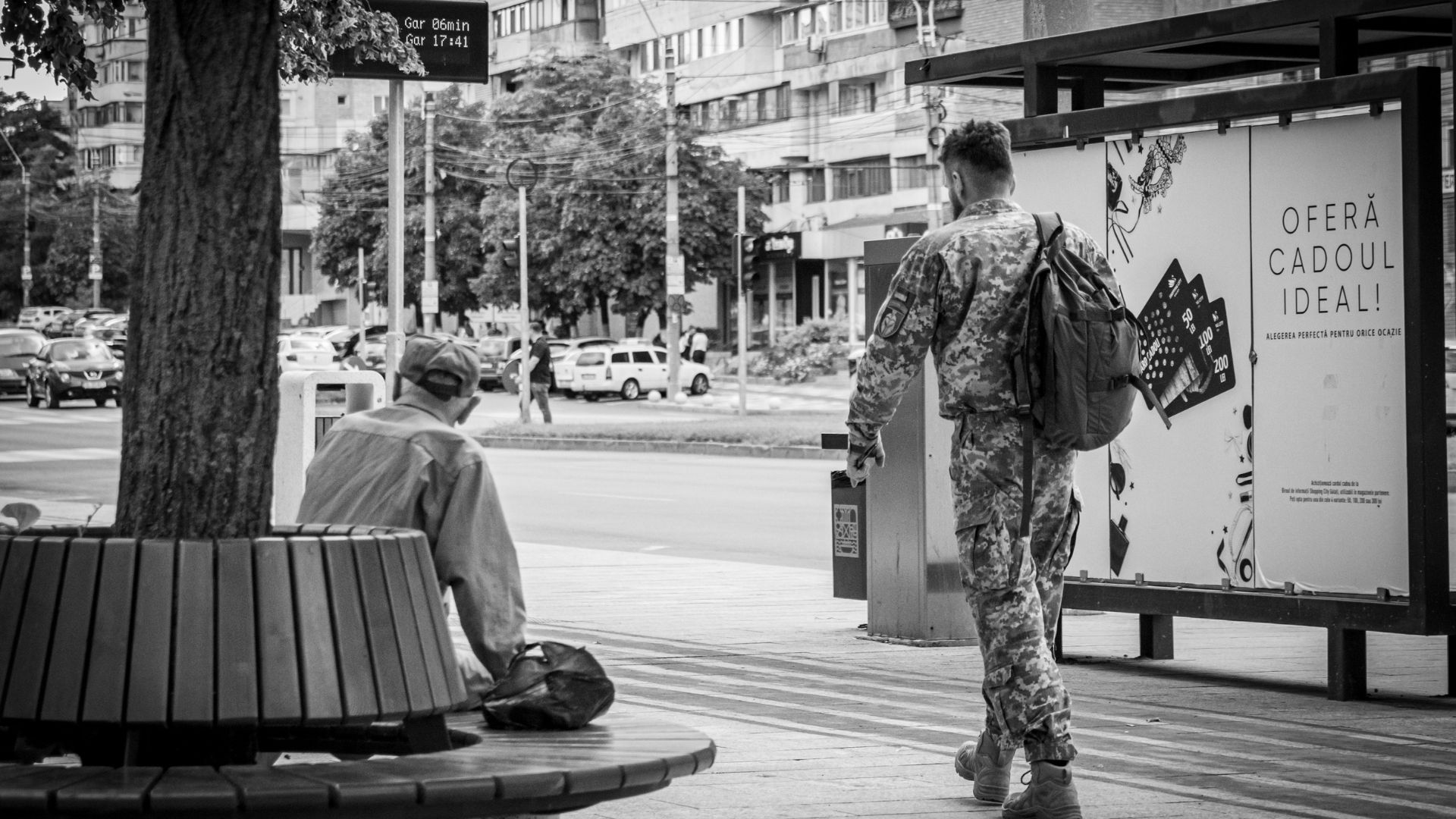 Two people sitting on benches facing away from each other in a quiet public area