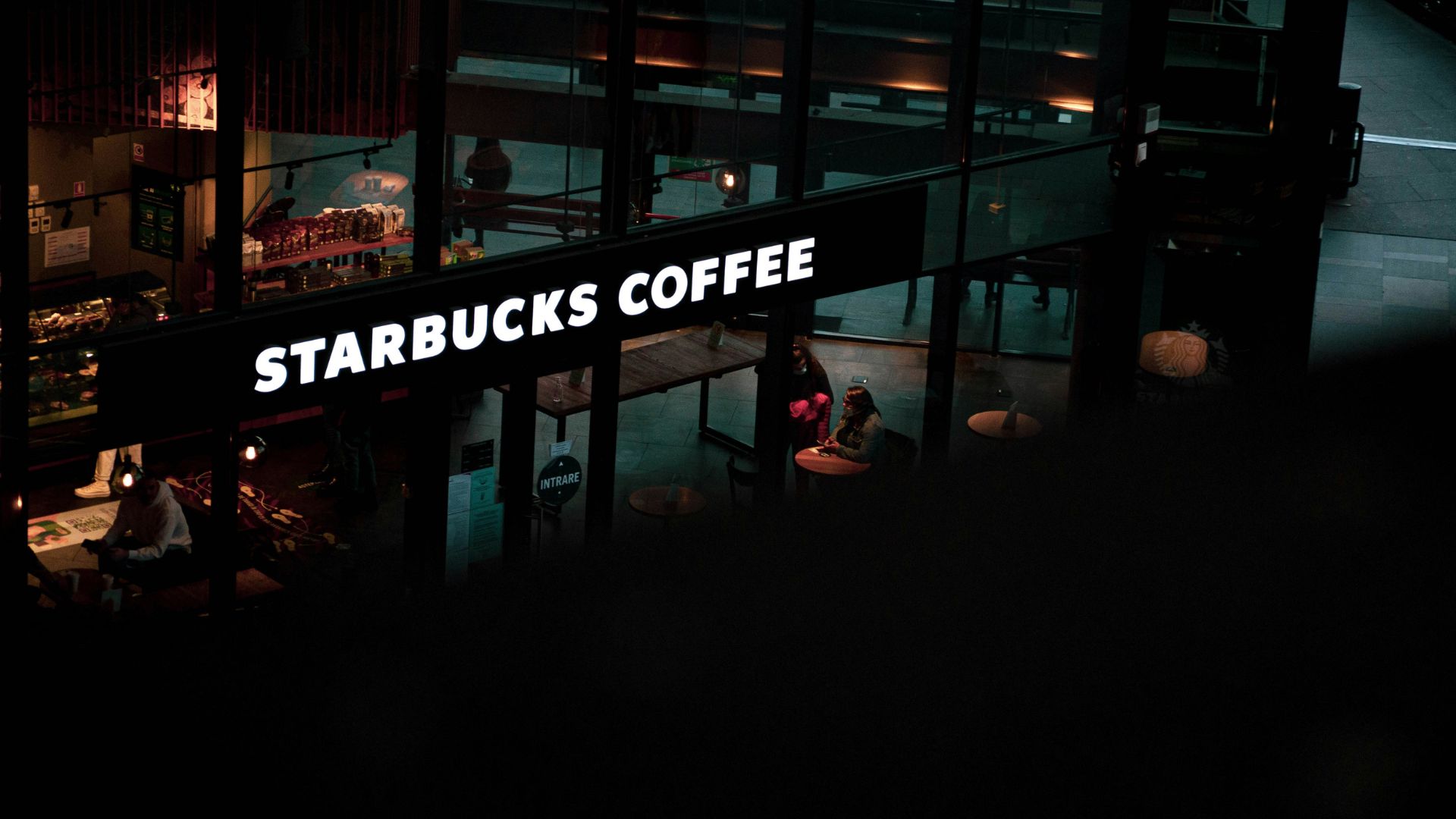 Starbucks sign hanging from the side of a building