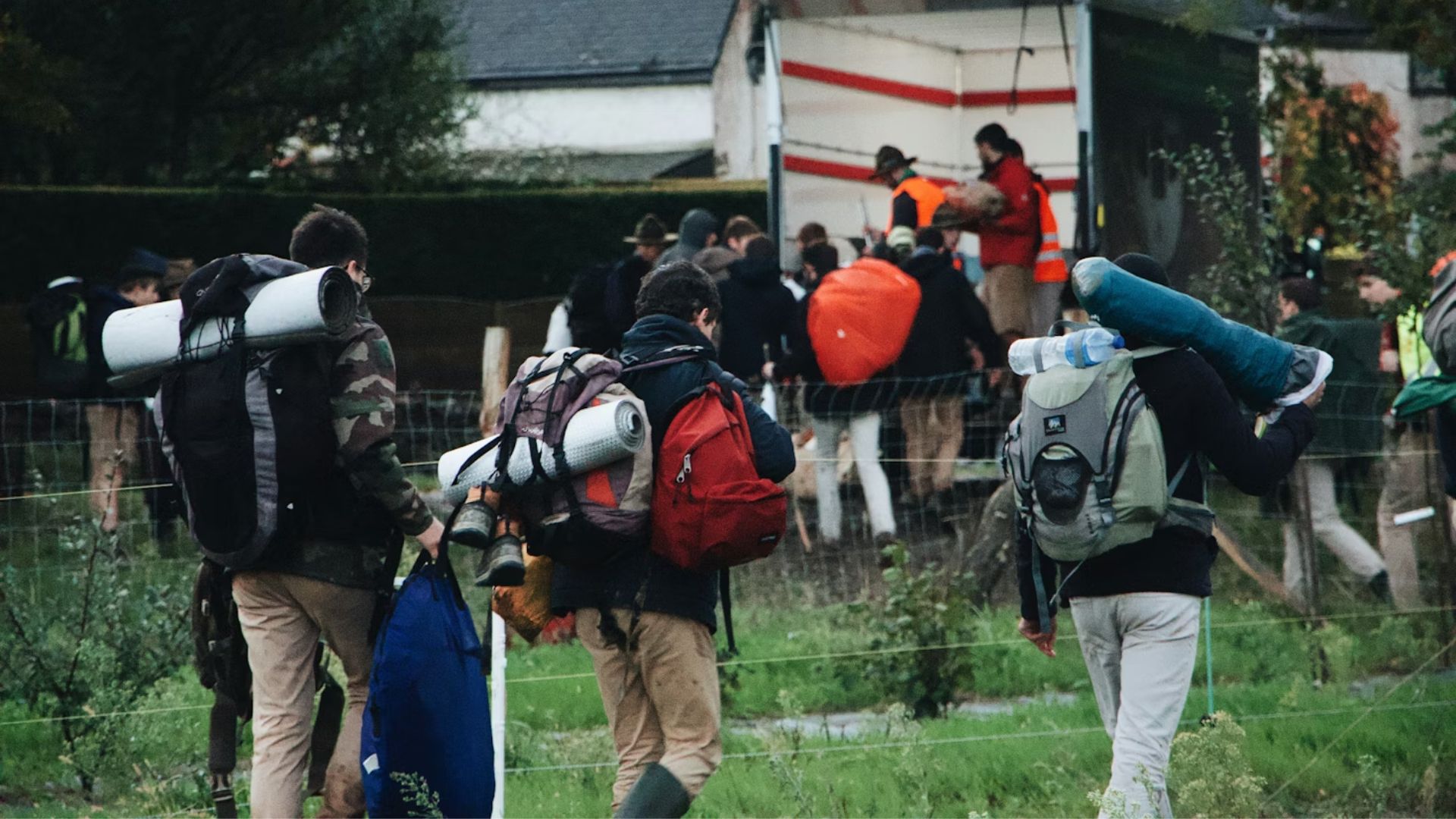 A group of people walking wearing hiking backpacks