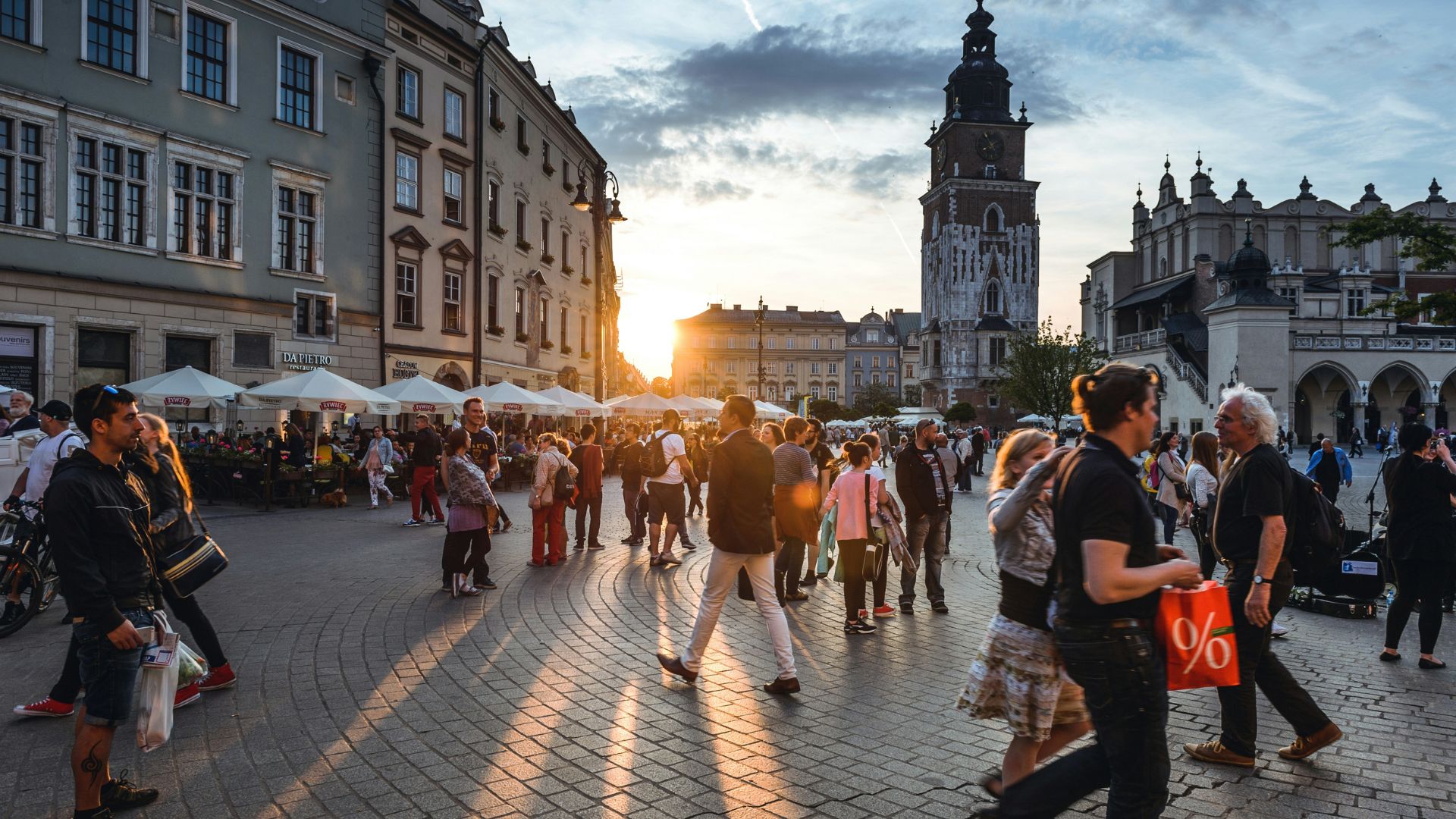People walking on a busy city street lined with tall concrete buildings