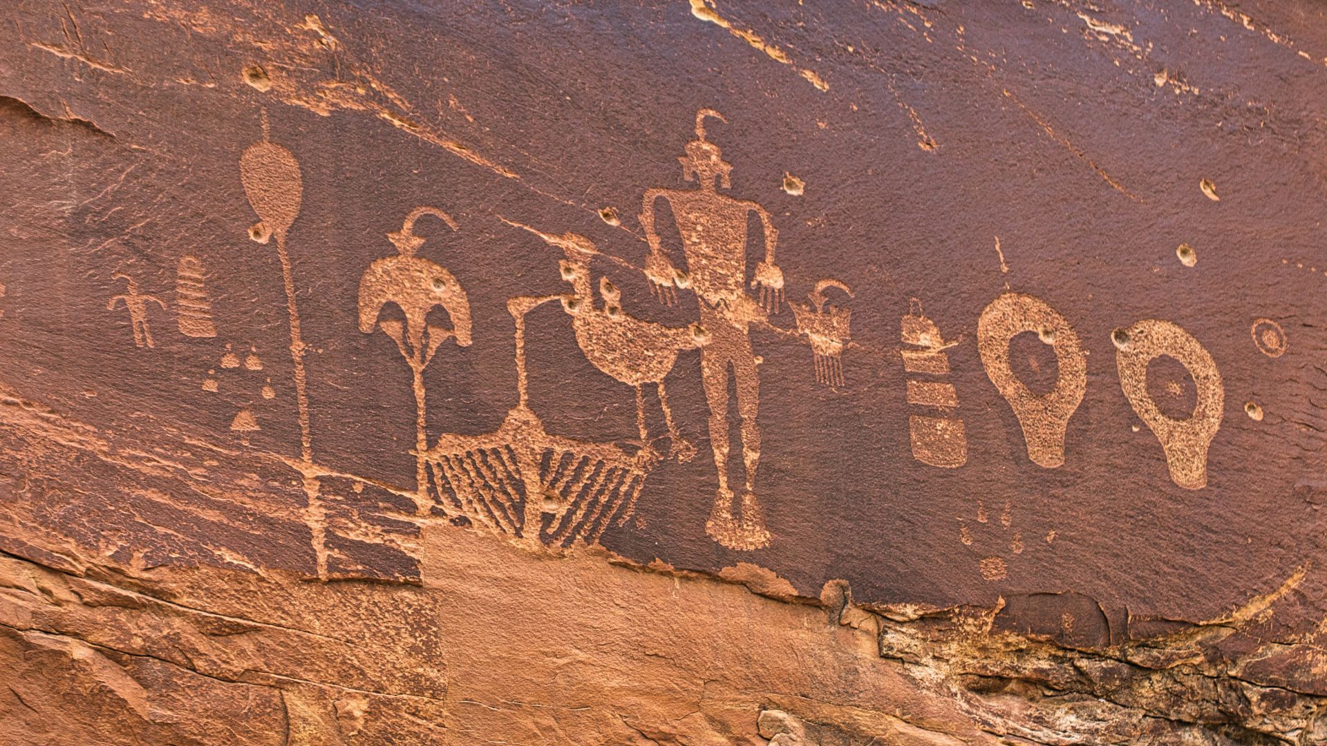 Rock surface displaying faded ancient drawings and symbols