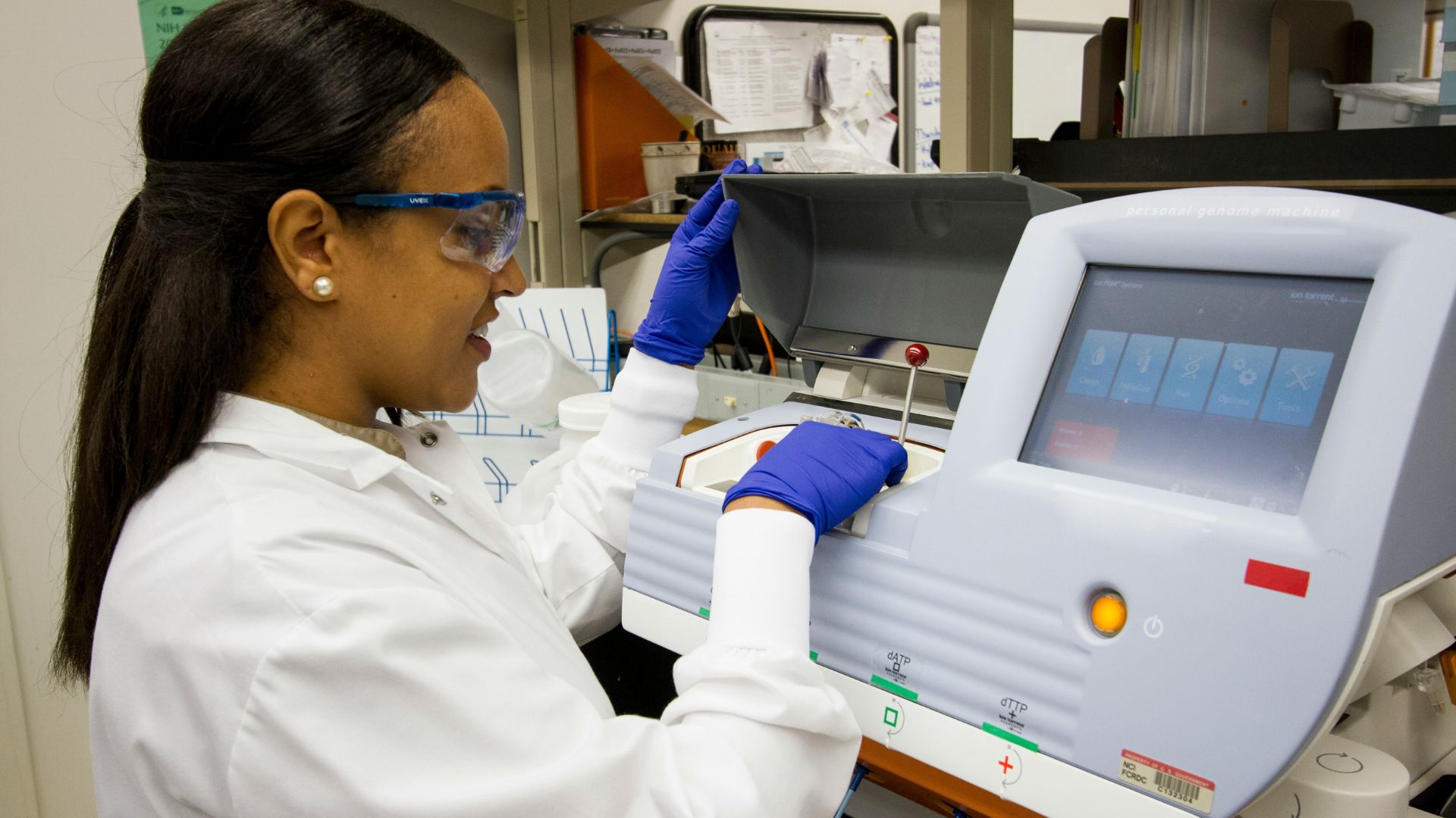 Woman in a white dress operating laboratory testing equipment