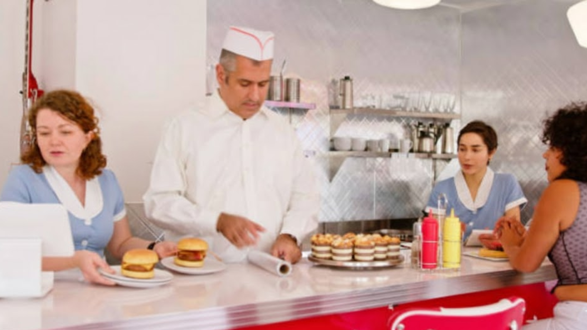 Inside a classic diner with staff behind the counter.