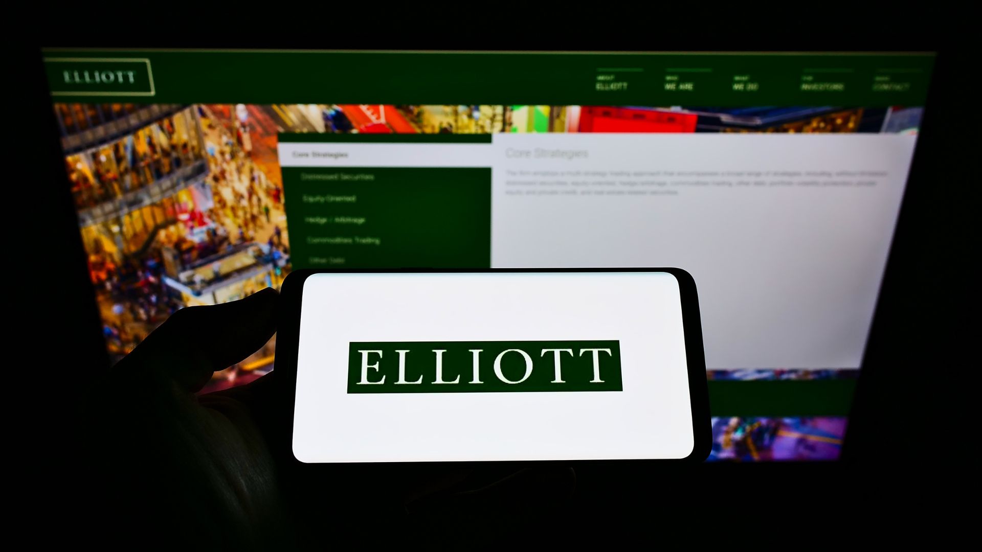 Person holding a smartphone displaying stock market data