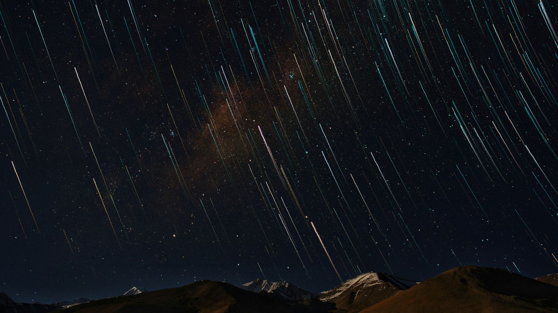 Desert landscape under a star-filled sky with a long exposure effect