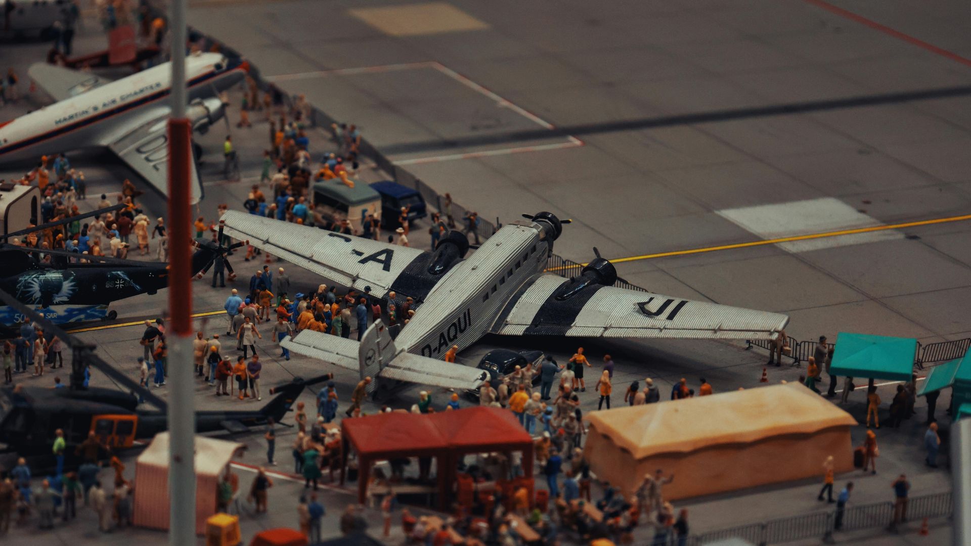 Toy airplane model surrounded by small figurines on a blue surface
