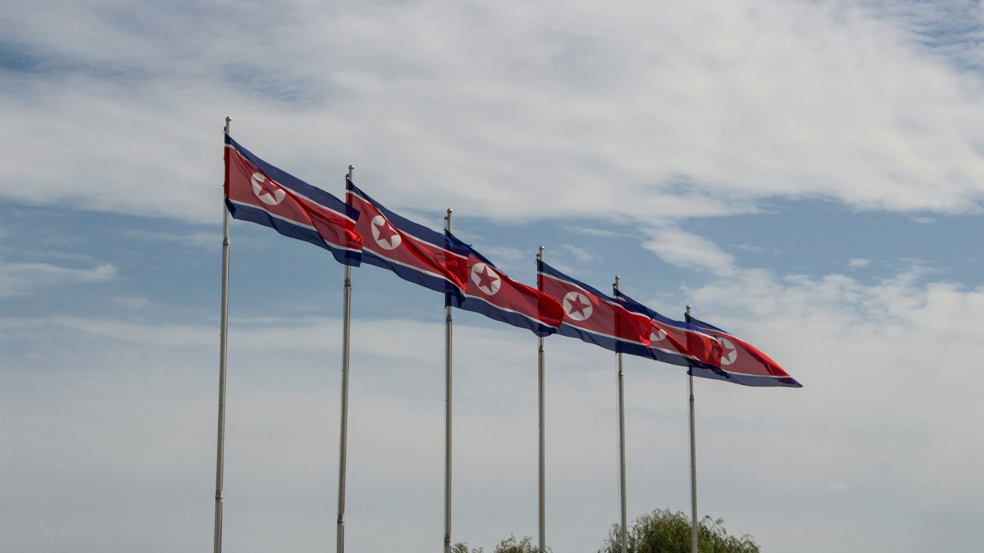 Red and white flags raised on tall poles in North Korea