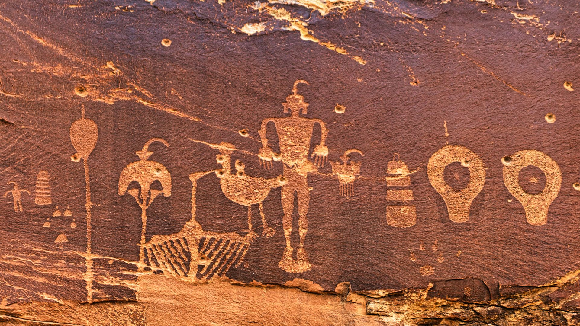 Rock surface covered with faded prehistoric drawings and symbols