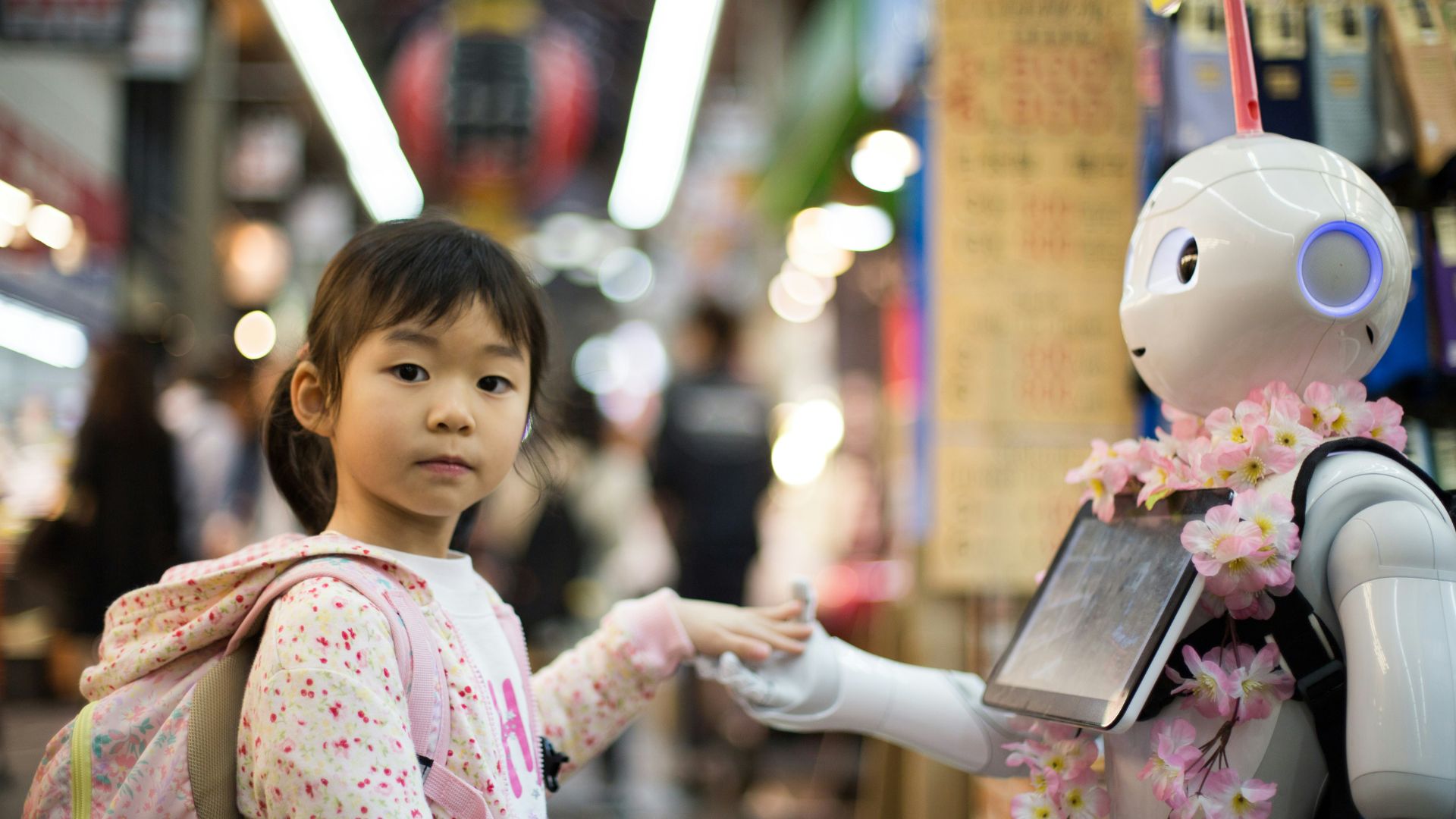 Person touching a humanoid robot with glowing digital elements