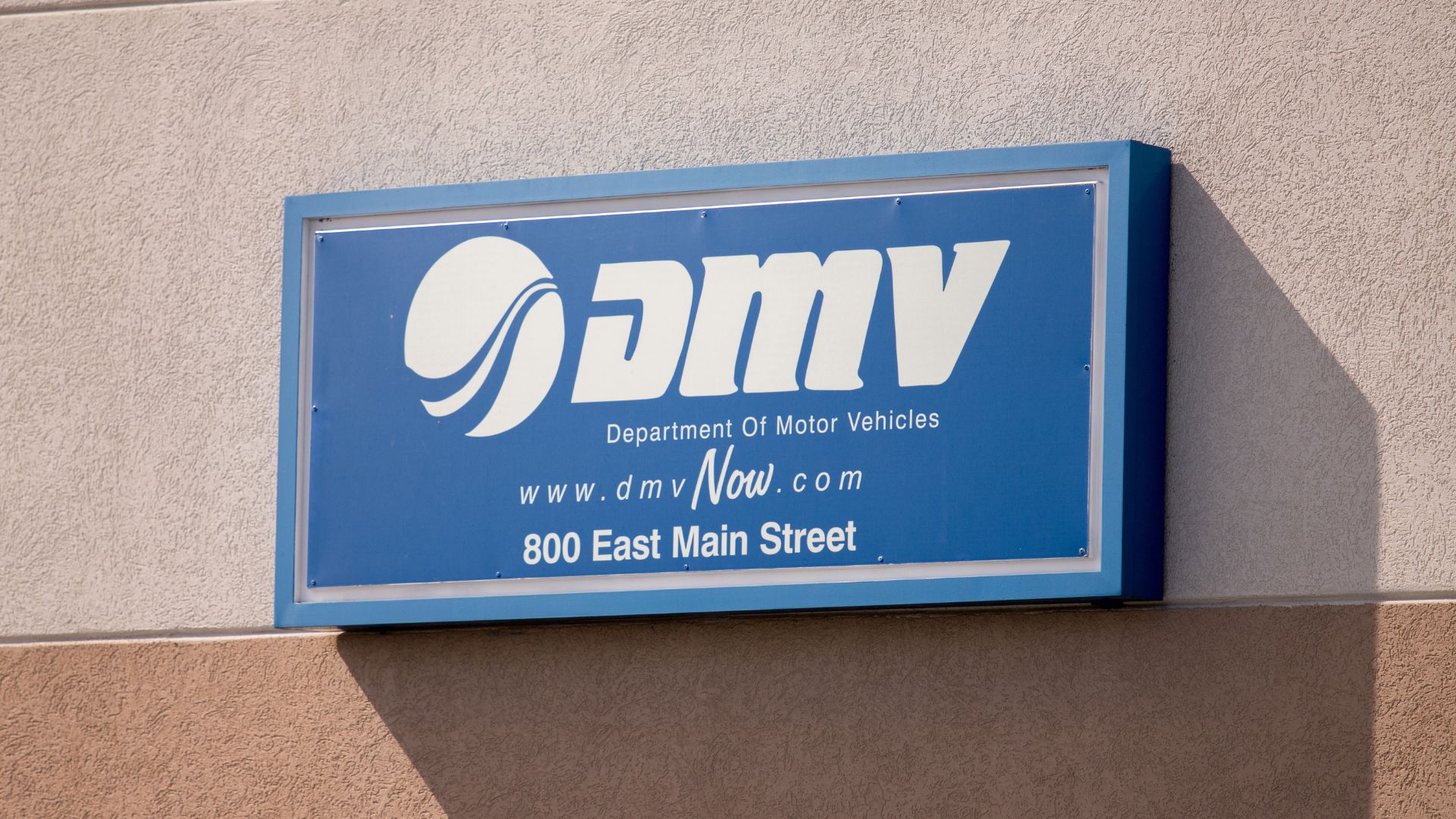 Exterior of a DMV building with its sign displayed over the entrance