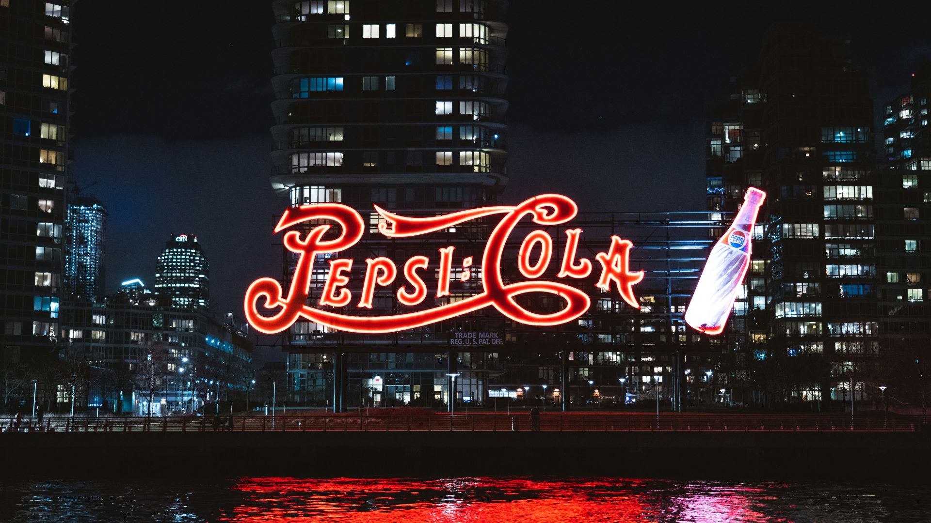 Red and white flag flying atop a building at night