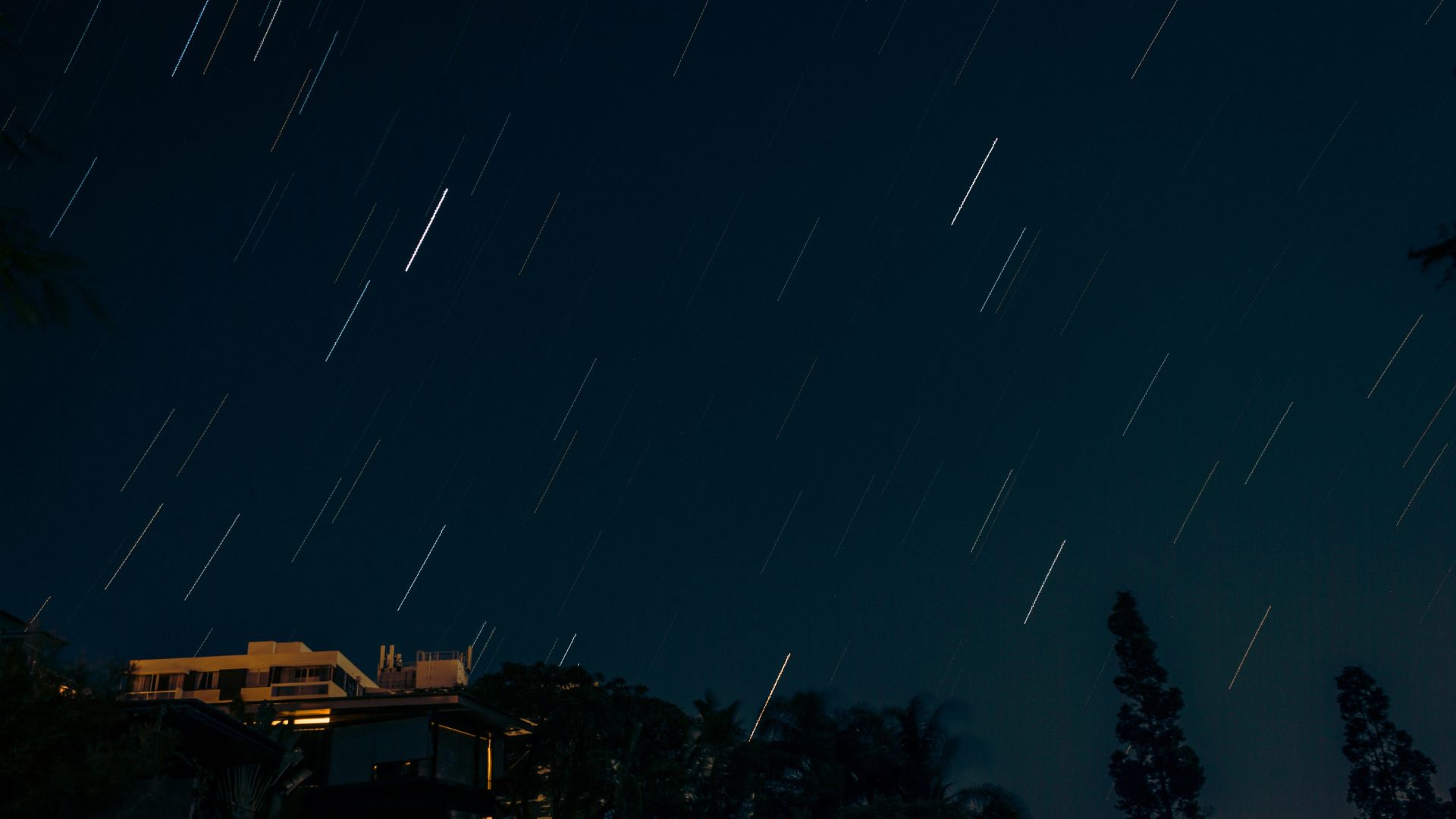 Cabin under a dark sky with stars visible above the roofline