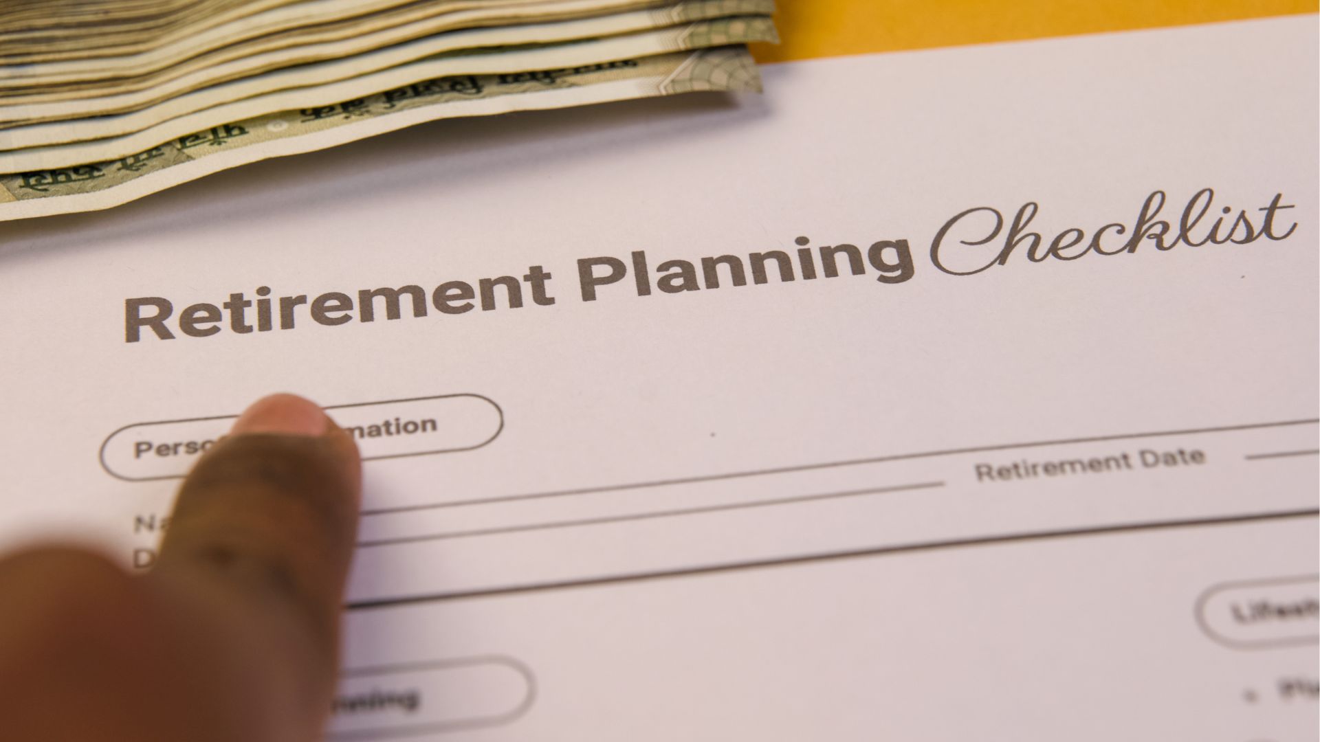 A person pointing at a retirement planning checklist