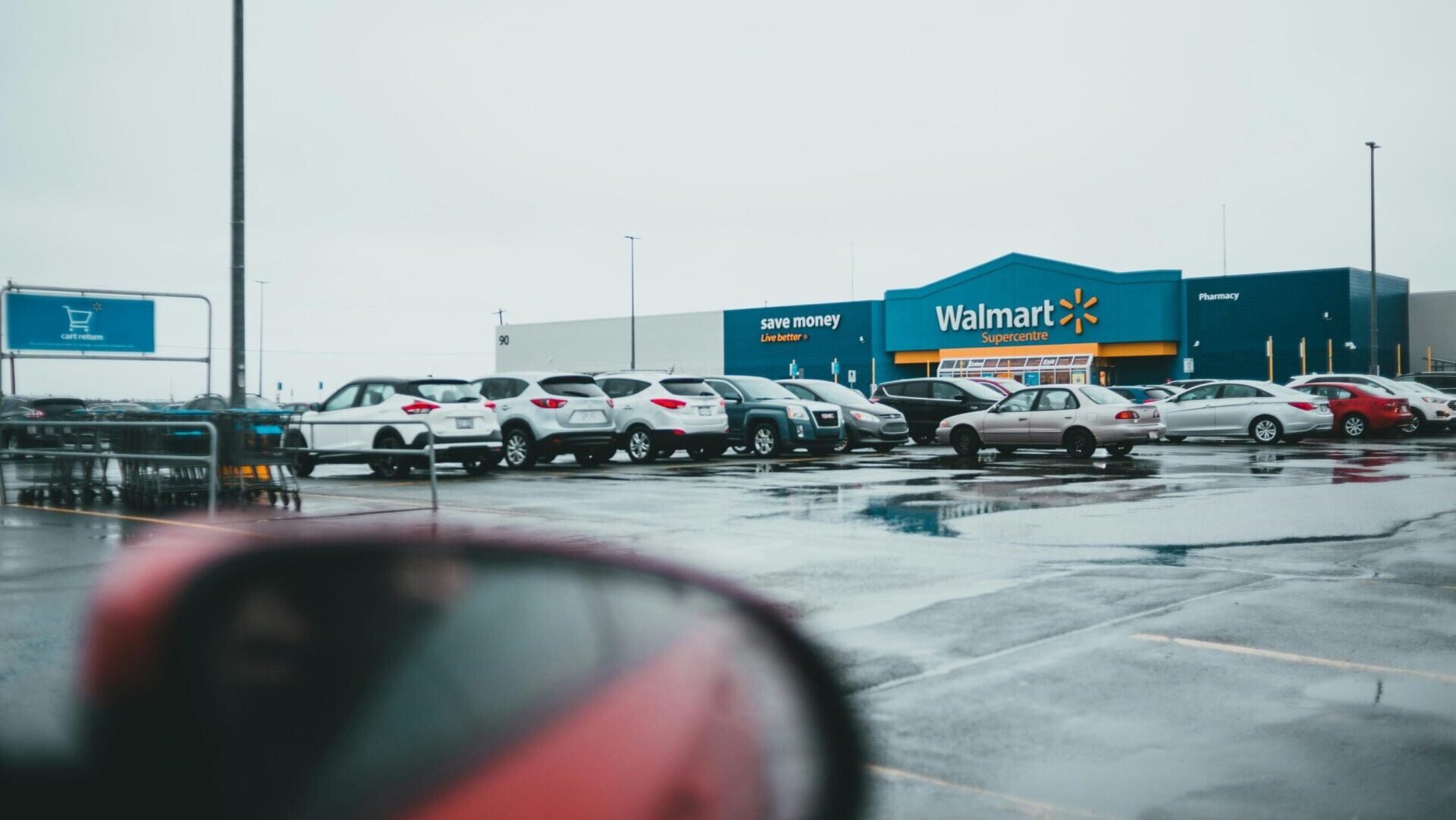 A car parked in a small parking lot near a local shop during daytime.