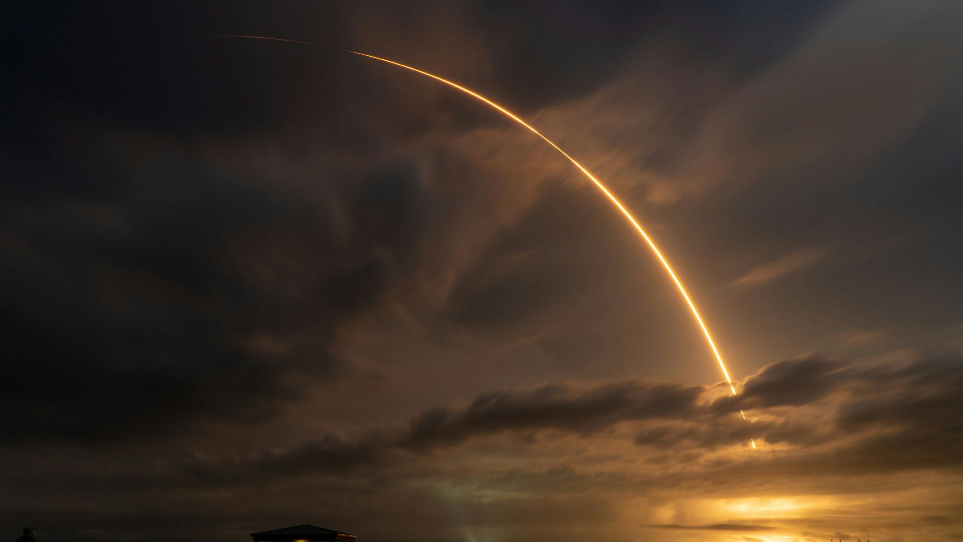 Large jet flying through layered clouds in the sky