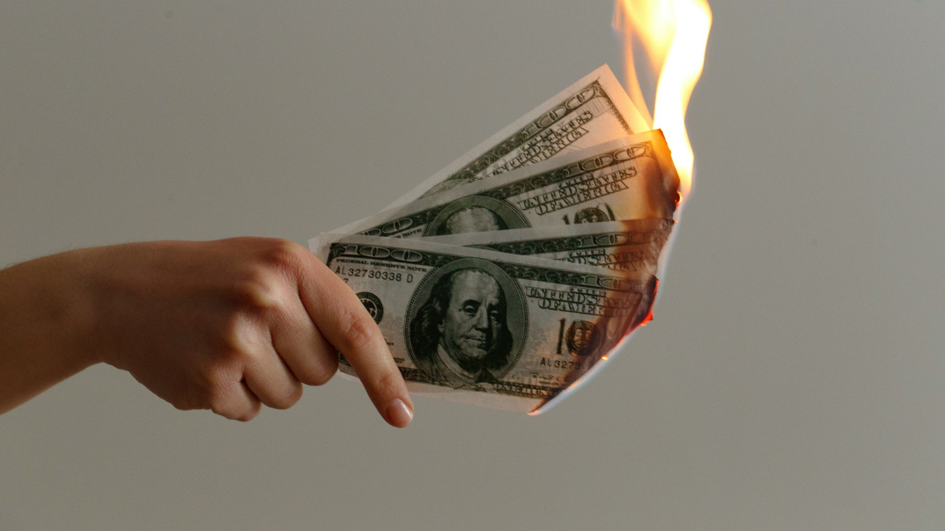 Burned one hundred dollar US banknotes symbolizing financial loss