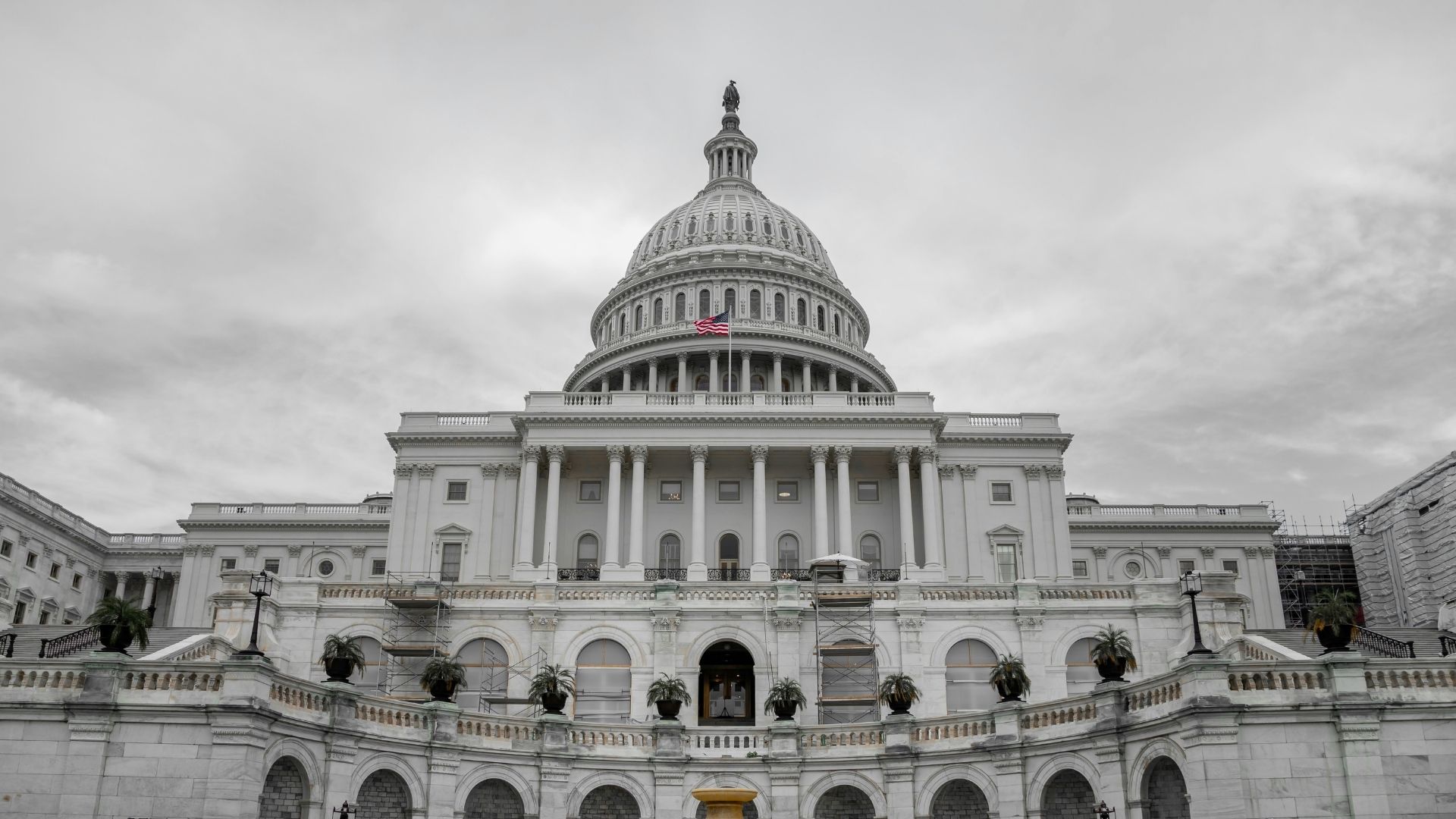 People walking near a large white concrete government building during daytime