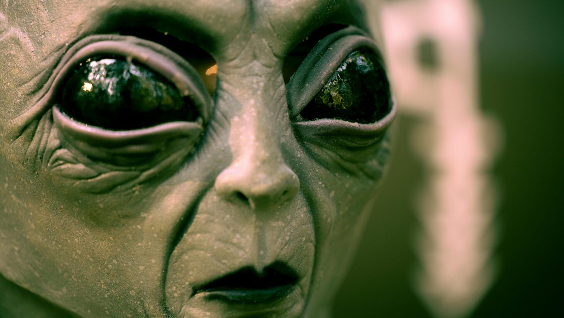 Close-up of a gray alien mask with large black eyes, perfect for a sci-fi or extraterrestrial theme.