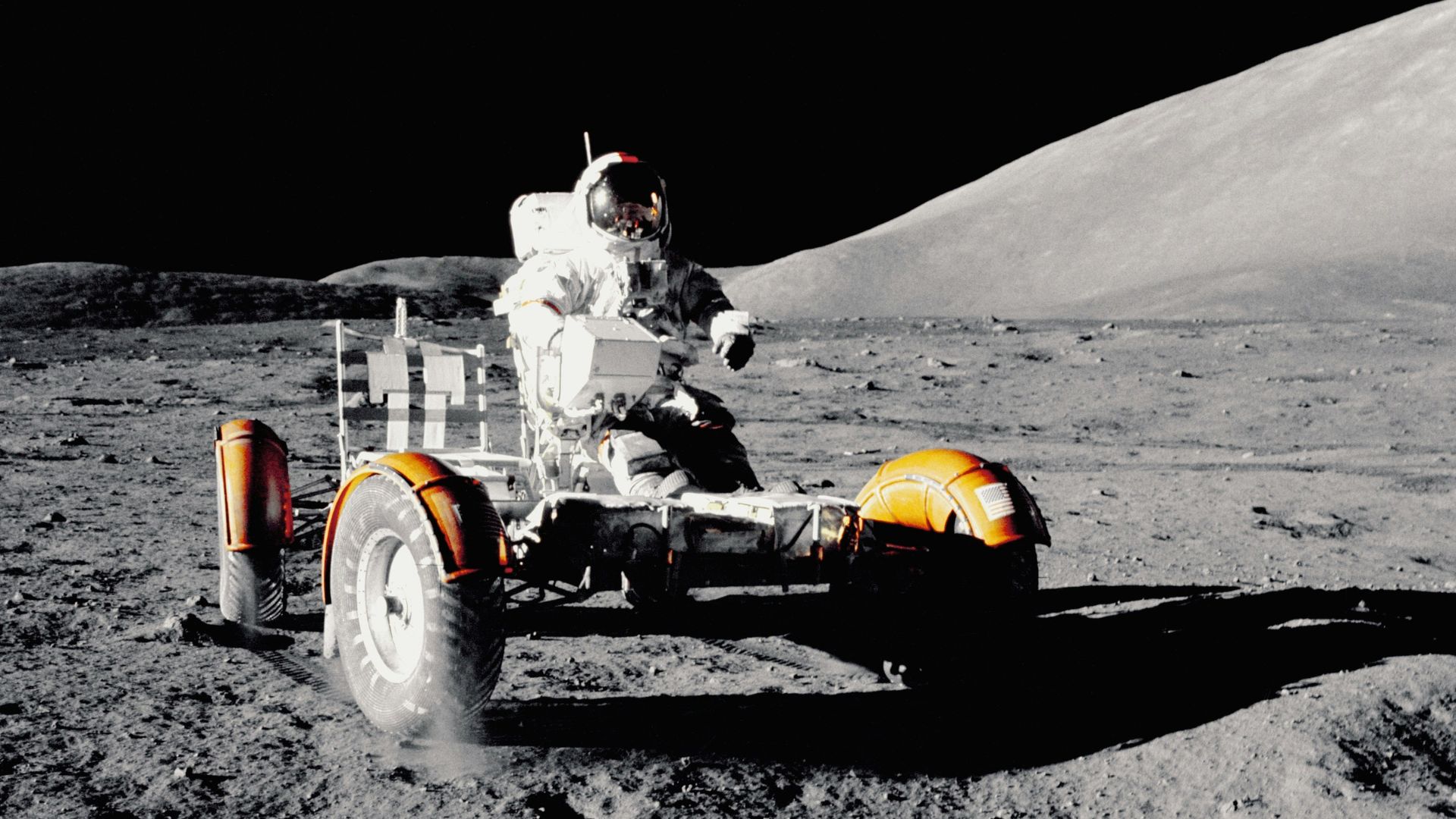Astronaut driving a lunar rover across the Moon’s surface