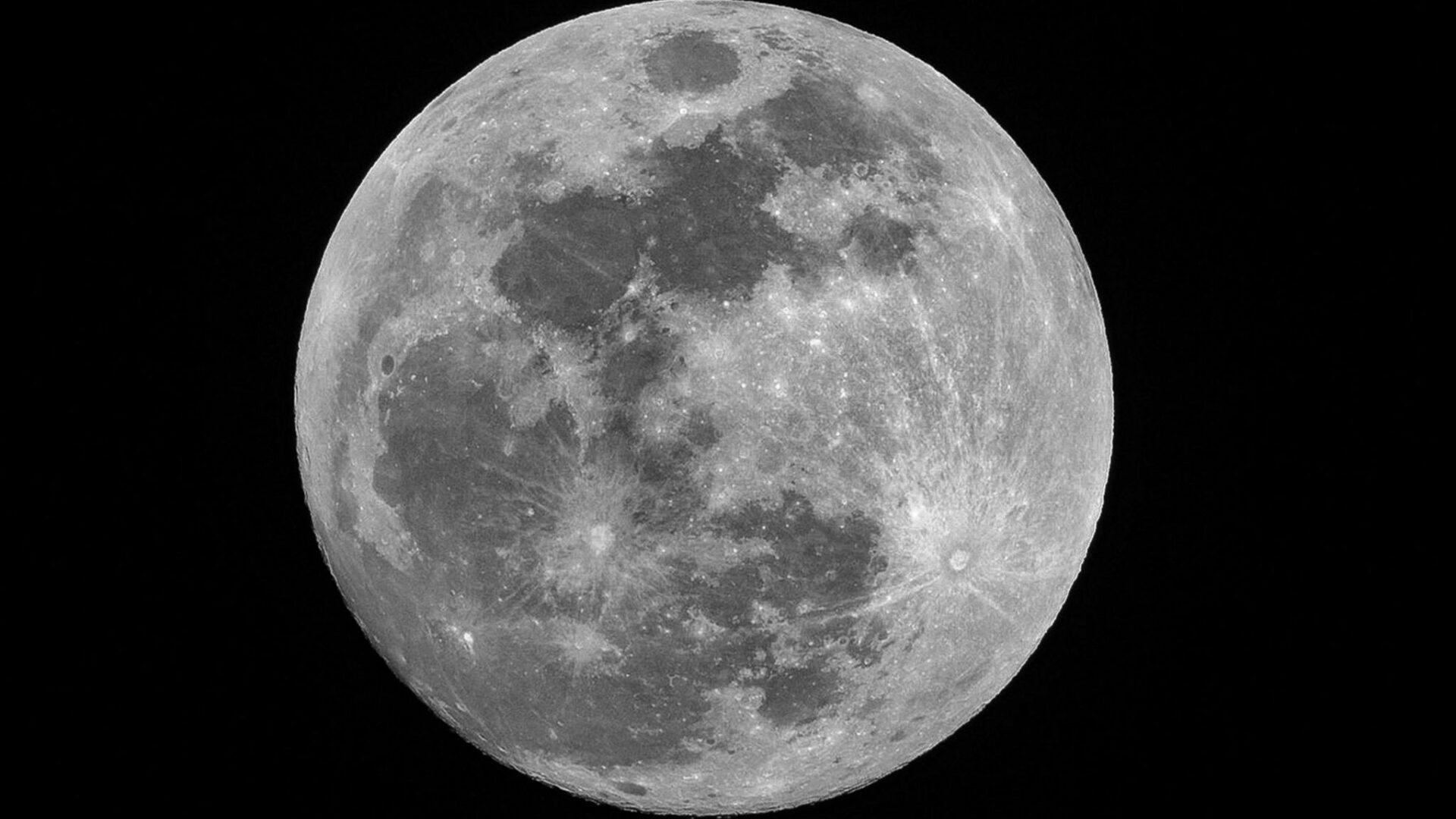 Detailed full moon illuminated against a dark background.