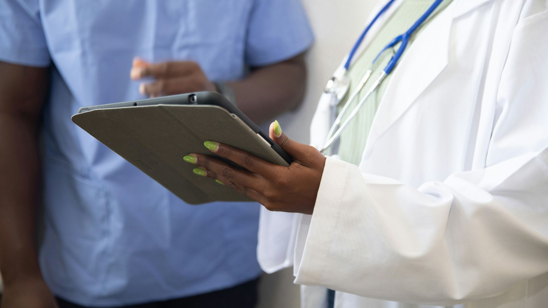 Doctor showing information to a patient on a tablet.