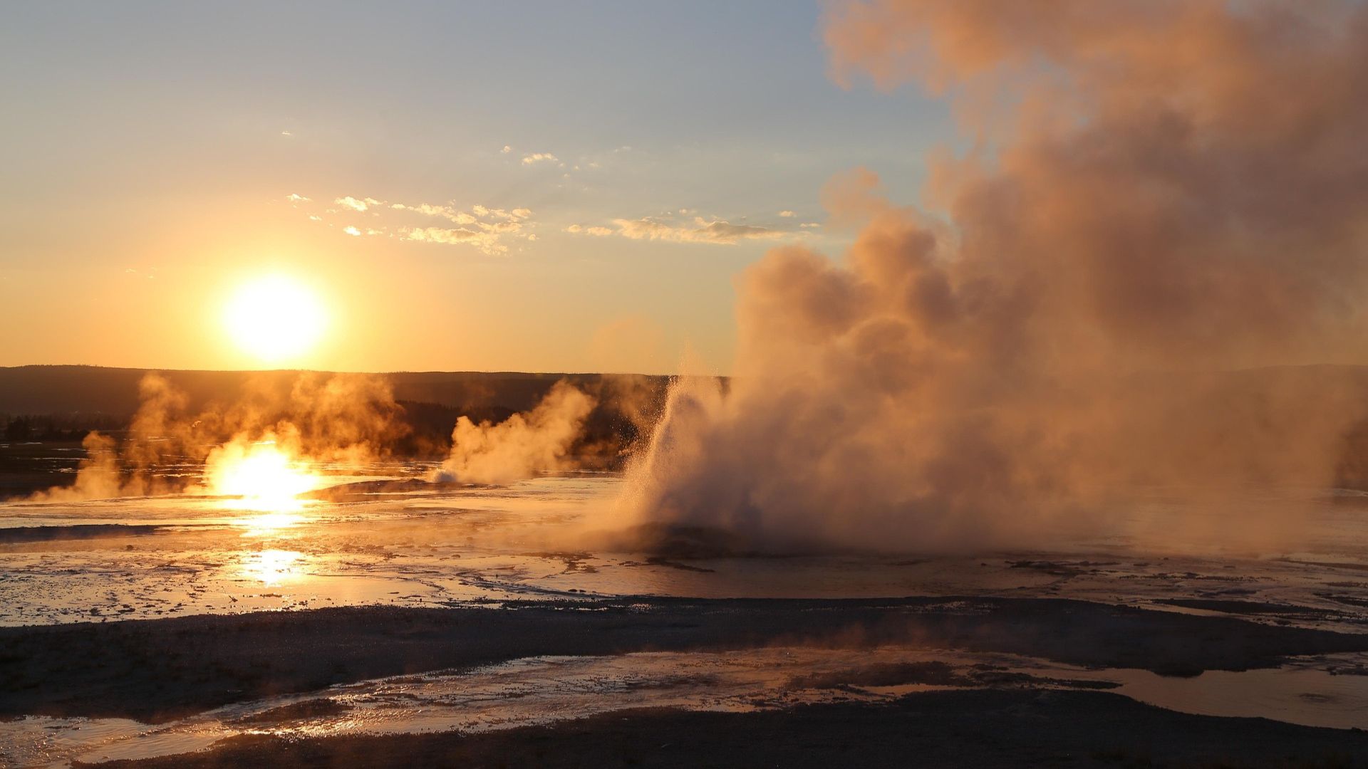 Steam coming off hot springs with the sun in the background