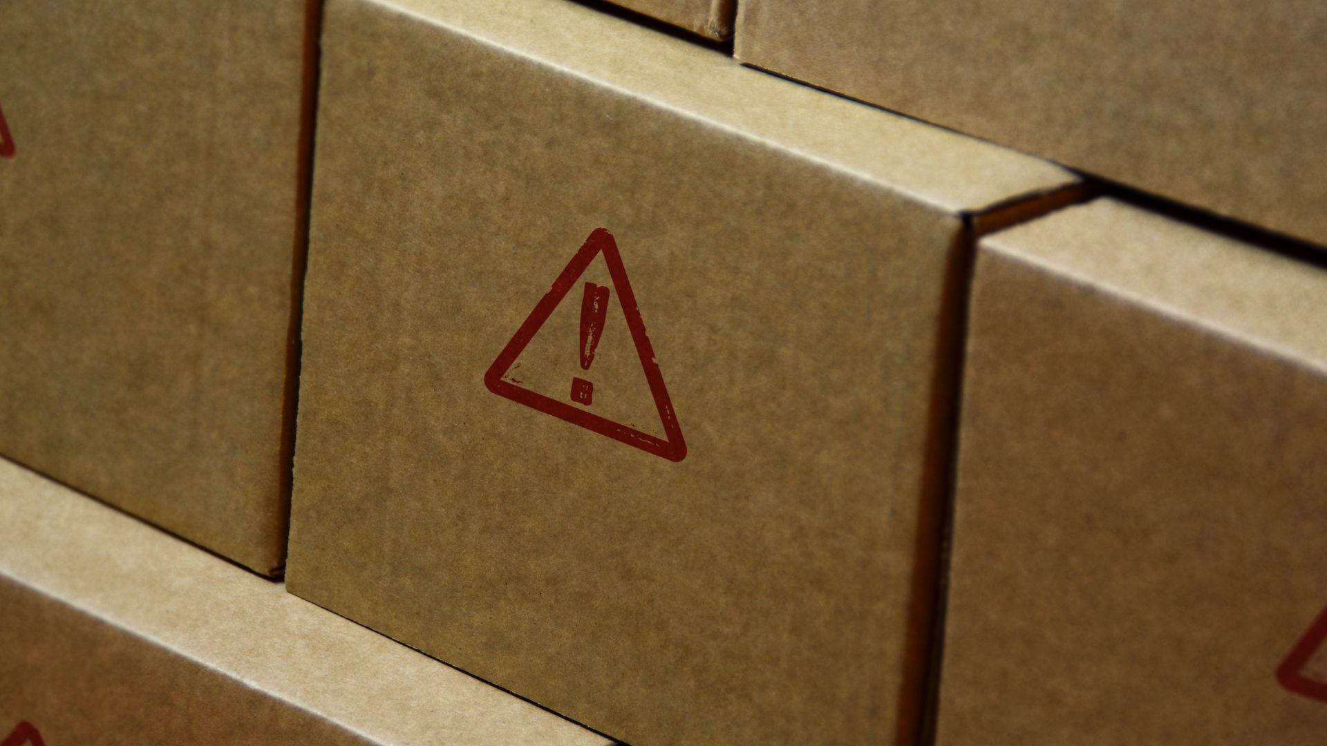 Red triangle with exclamation mark on a brown box