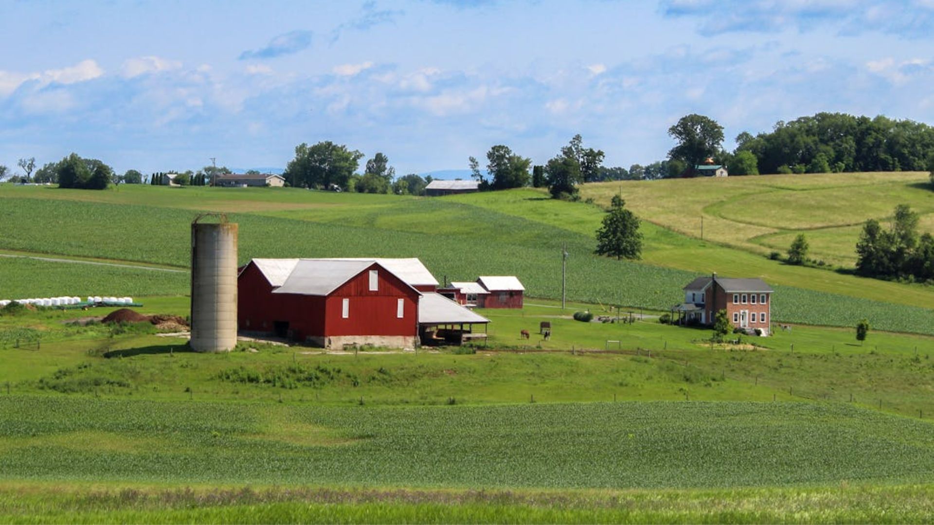 Stock photo of a picturesque rural farm with a red barn and silo