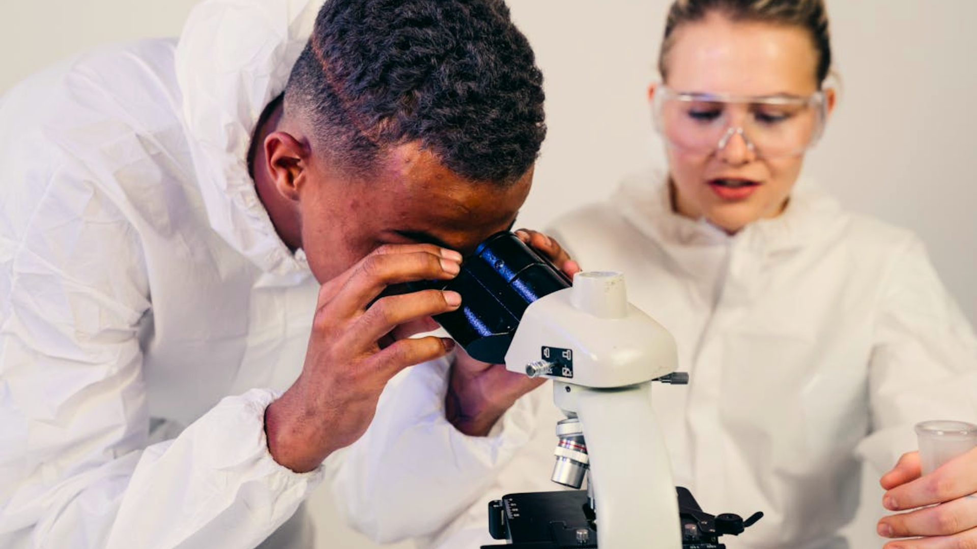 scientist looking at microscope
