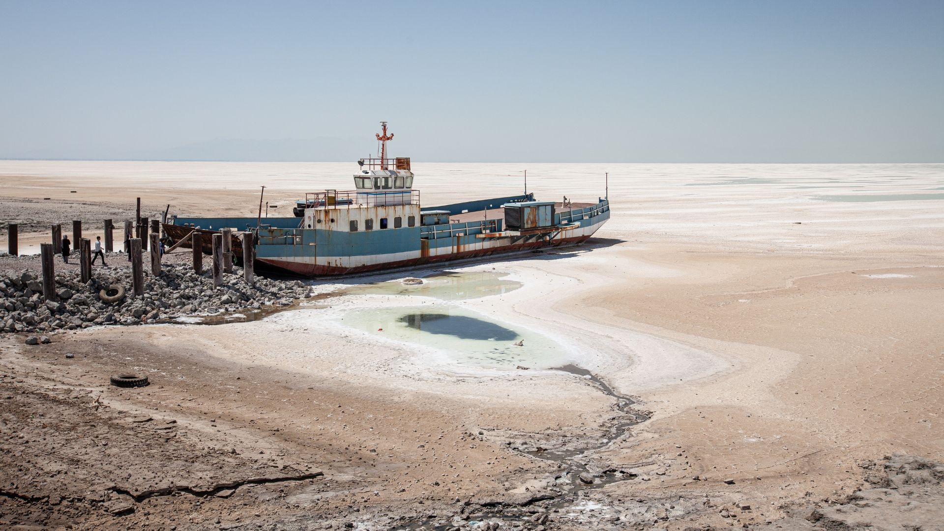 An image of Lake Urmia without water with a beached rusty ship near what looks like a dock