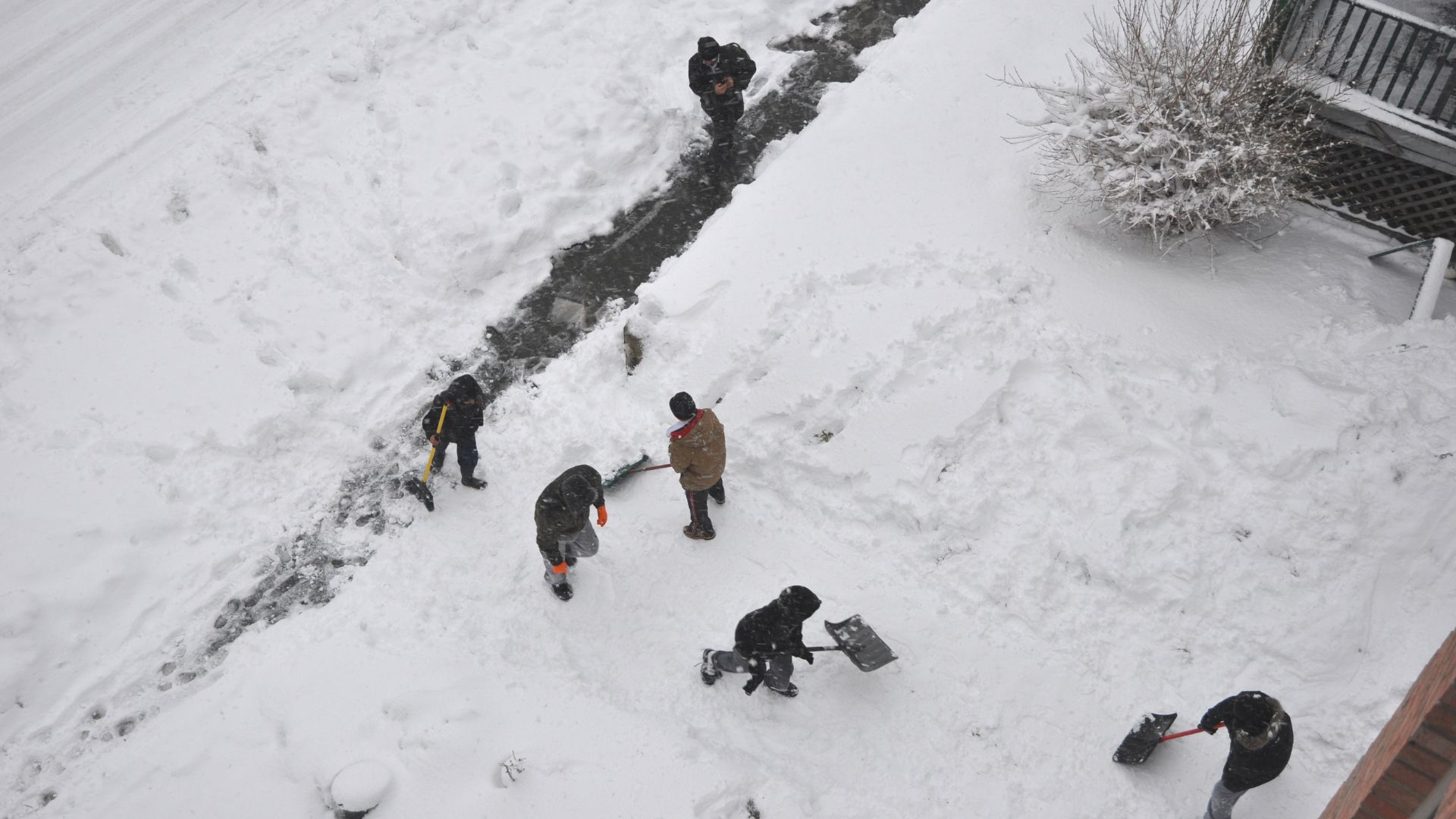 Men cleaning the walkway of the street