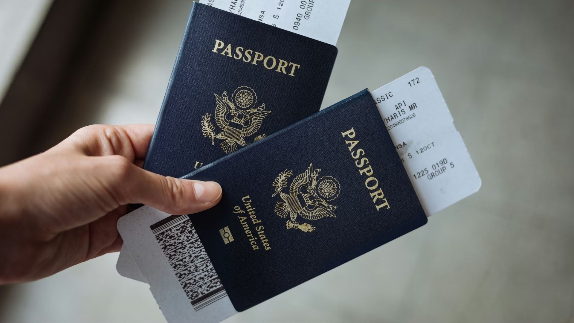A hand holding two U.S. passports