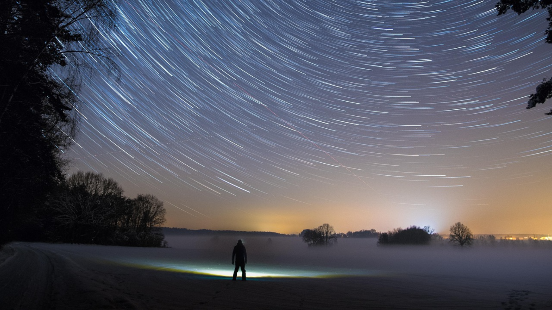 Man looking at star trail in the sky