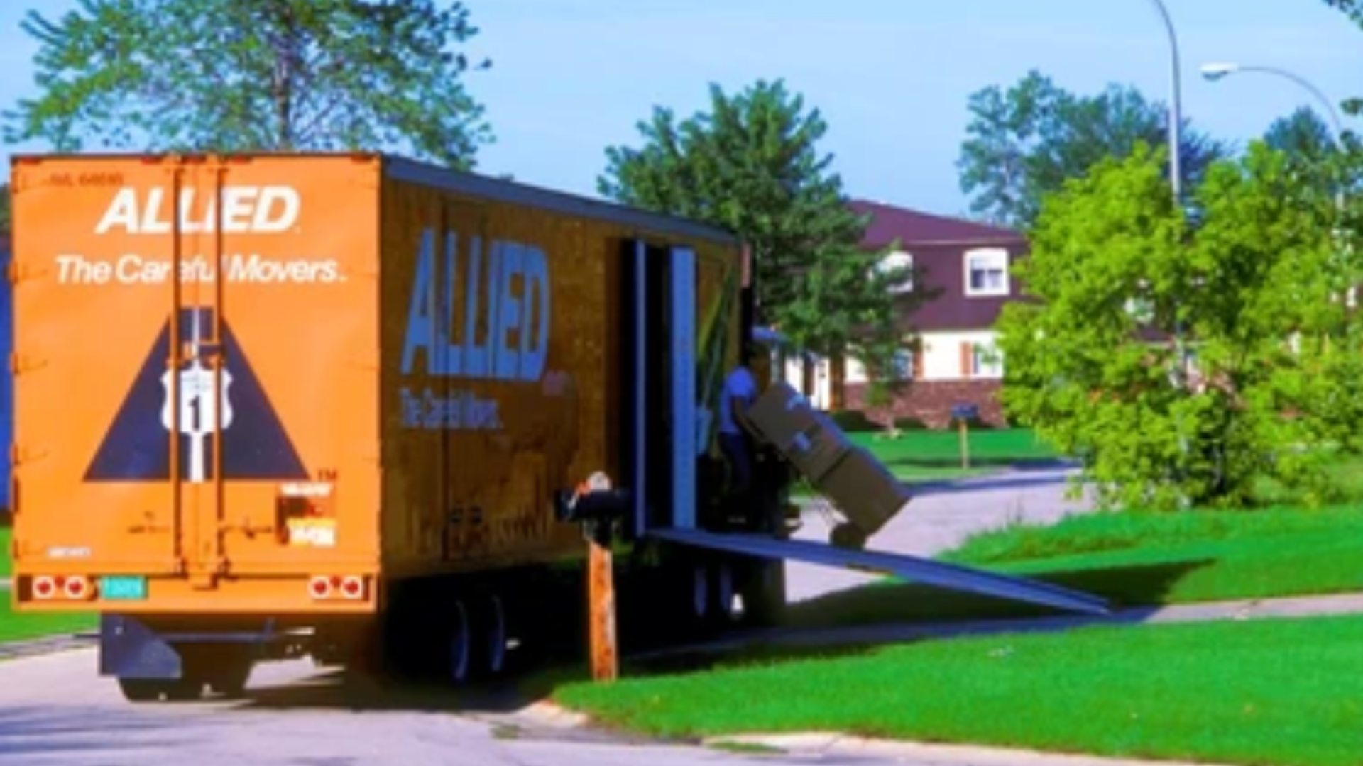 Moving truck parked in a neighborhood with someone loading boxes.