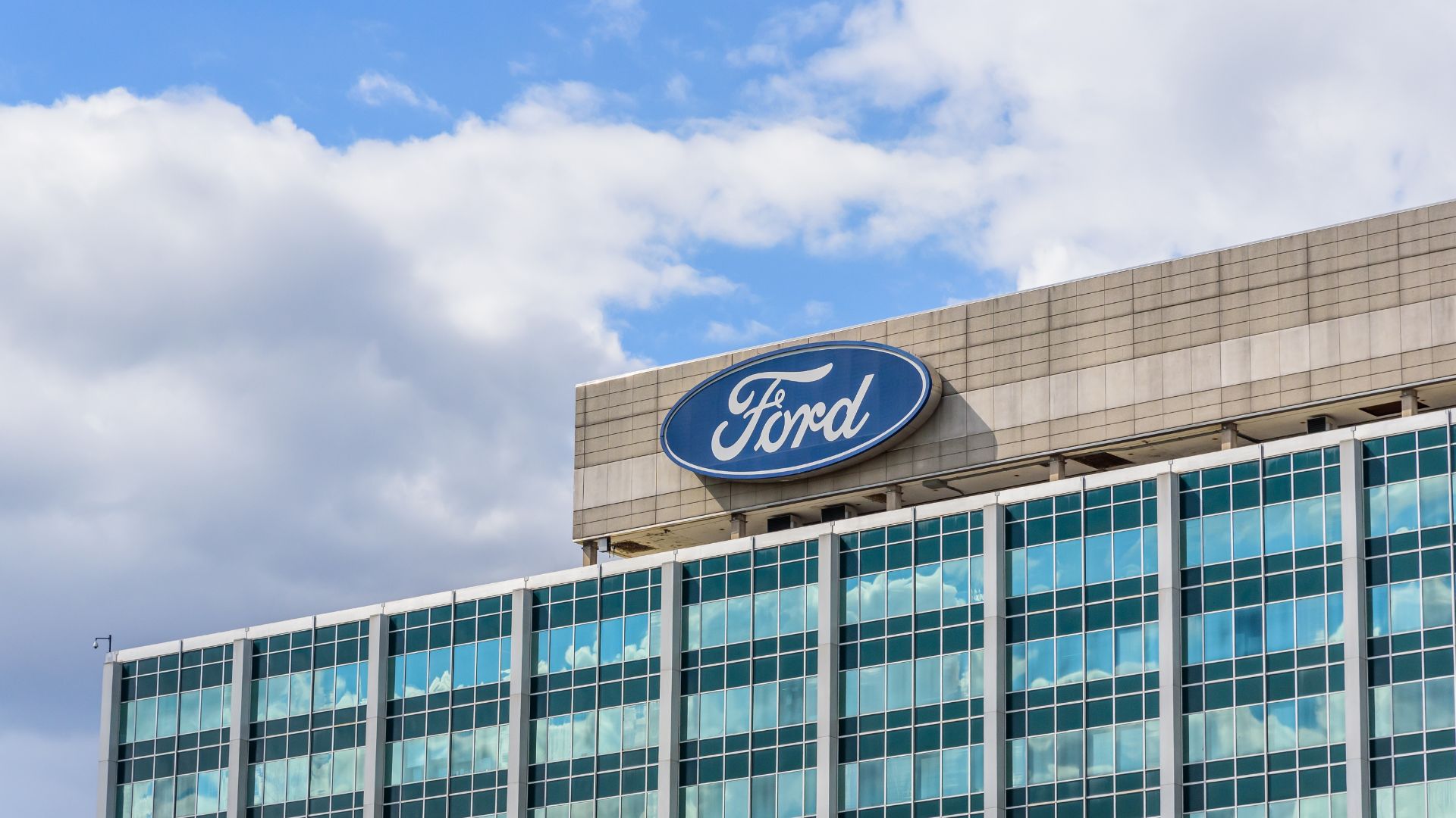 Ford corporate headquarters building in Dearborn, Michigan with large blue Ford logo on exterior.