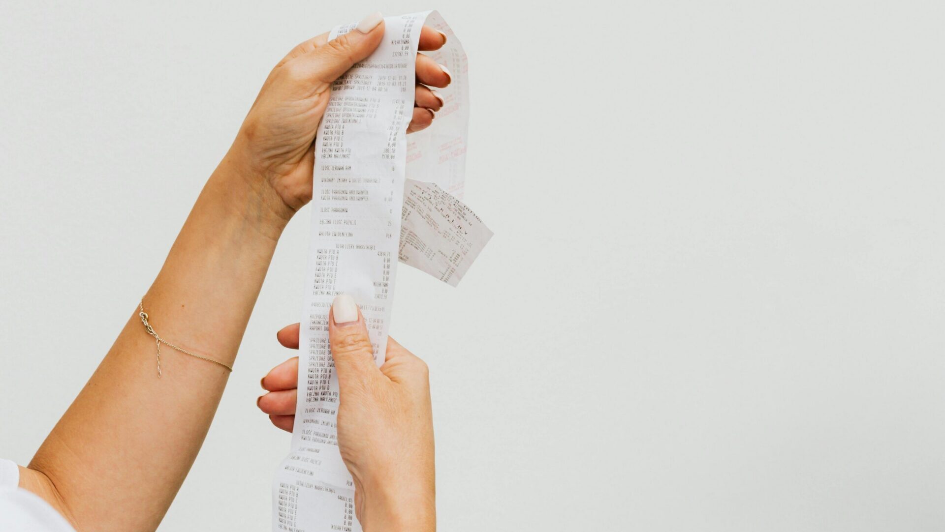 Woman holding a receipt while standing in a store aisle.