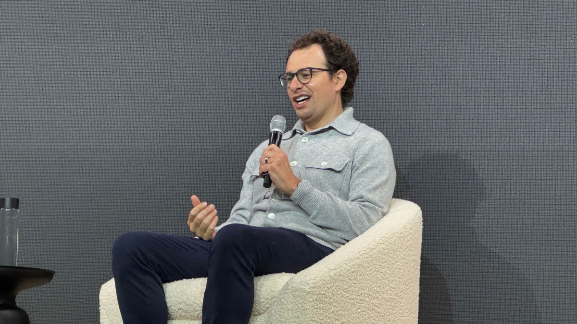 Tech executive speaking on stage during a conference panel discussion about artificial intelligence.