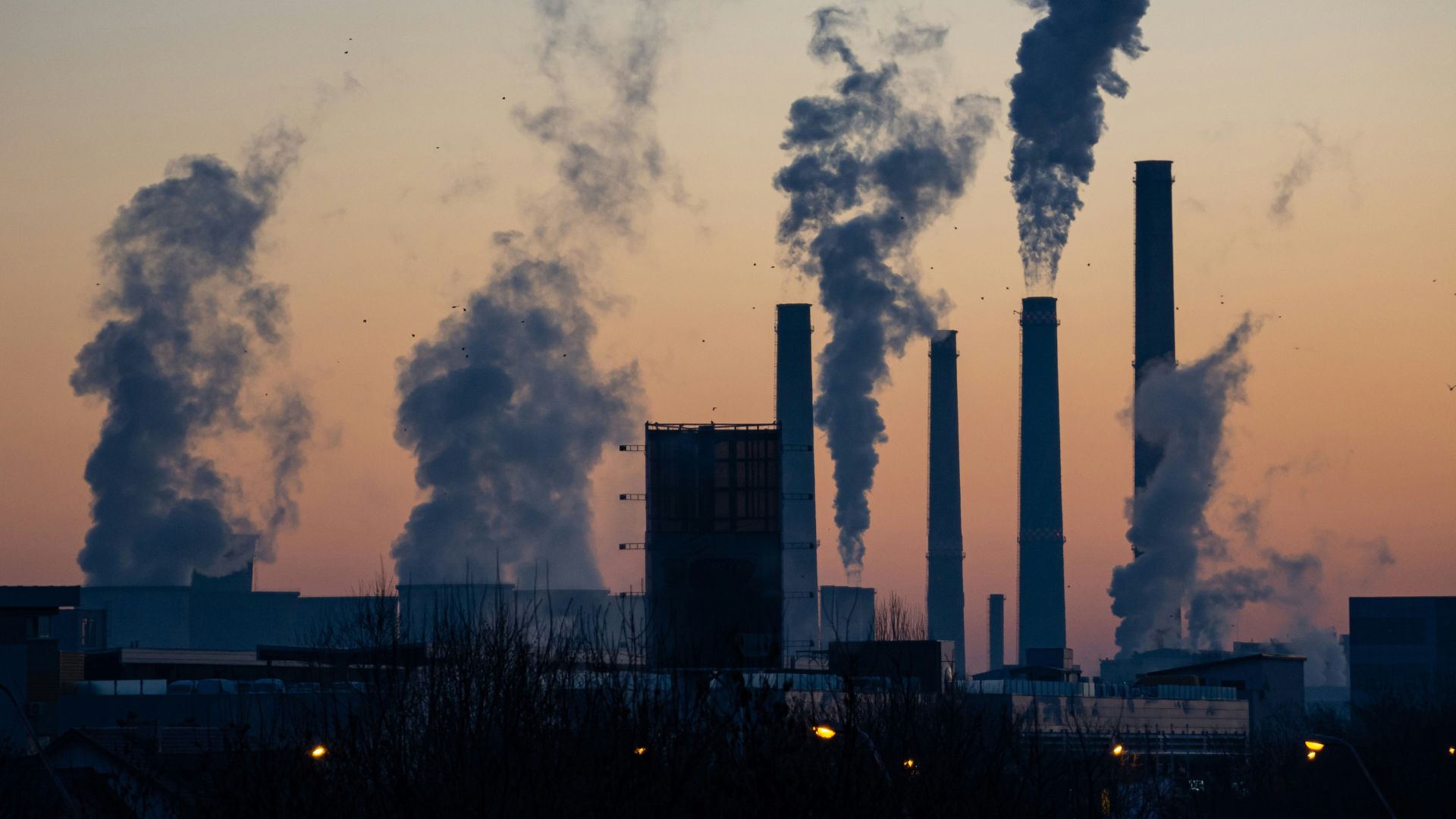 Thick vehicle exhaust smoke emitting from a car tailpipe contributing to air pollution