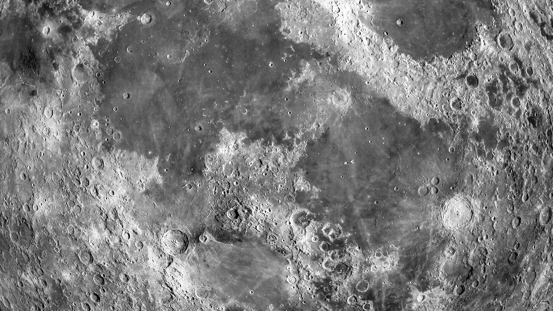 Close-up of the moon’s cratered surface showing detailed texture and ridges