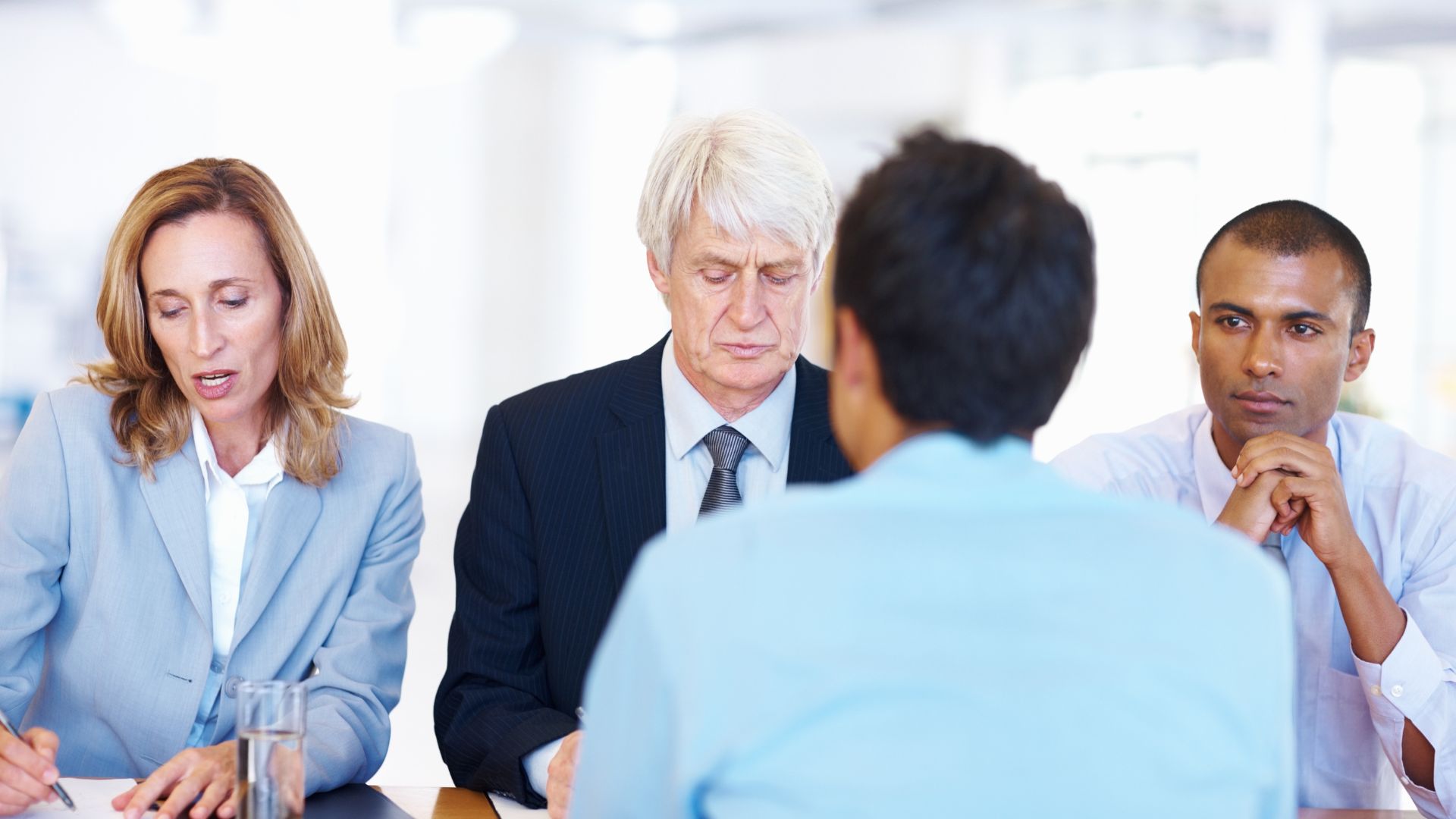 Panel of interviewers speaking with a job applicant during a formal business interview.