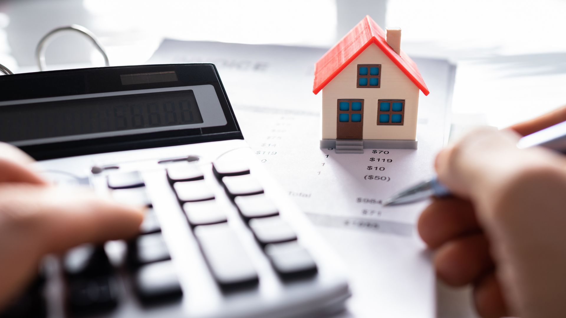 A person calculating a real estate expense