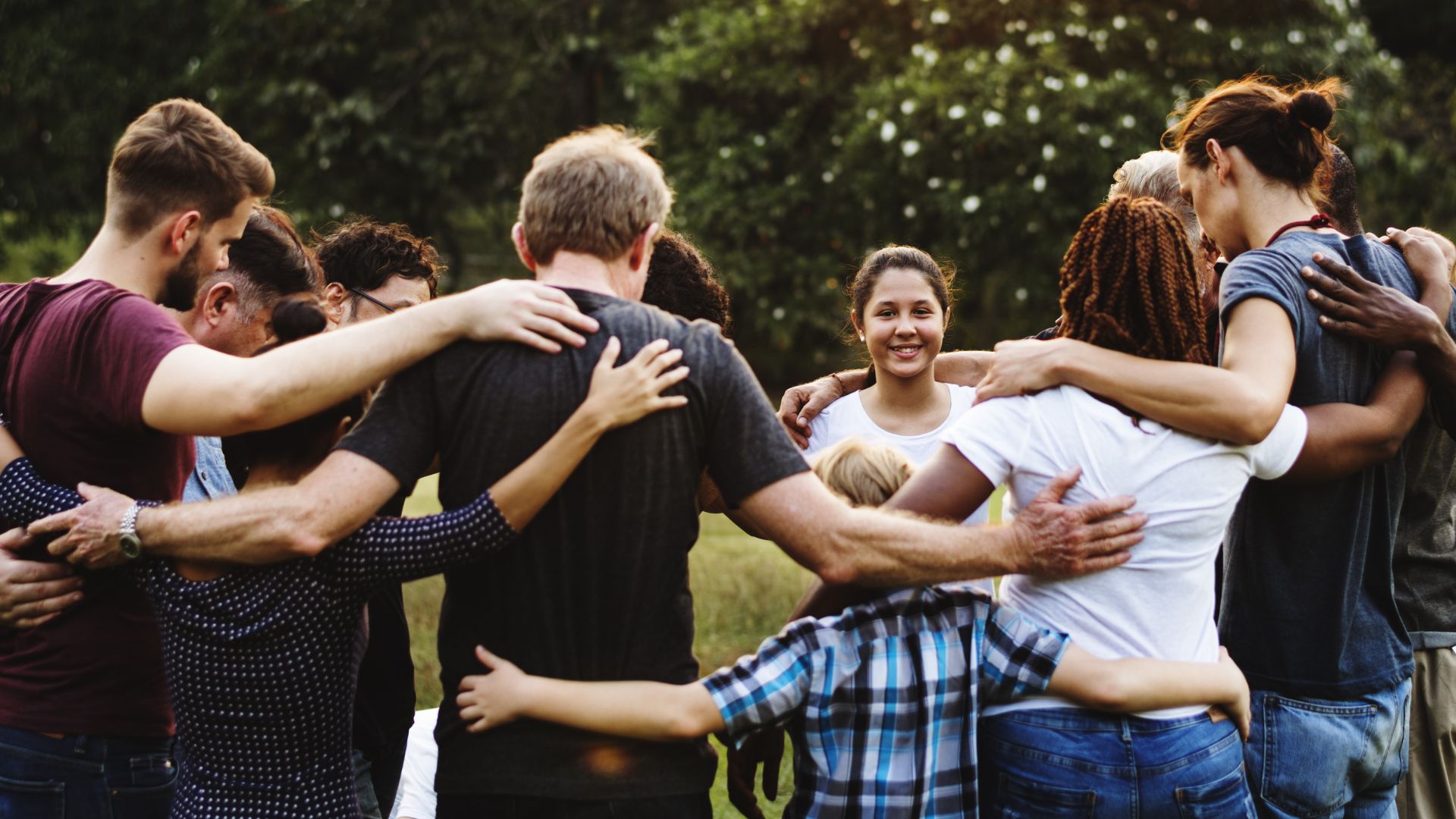 Group of people huddle together in the park