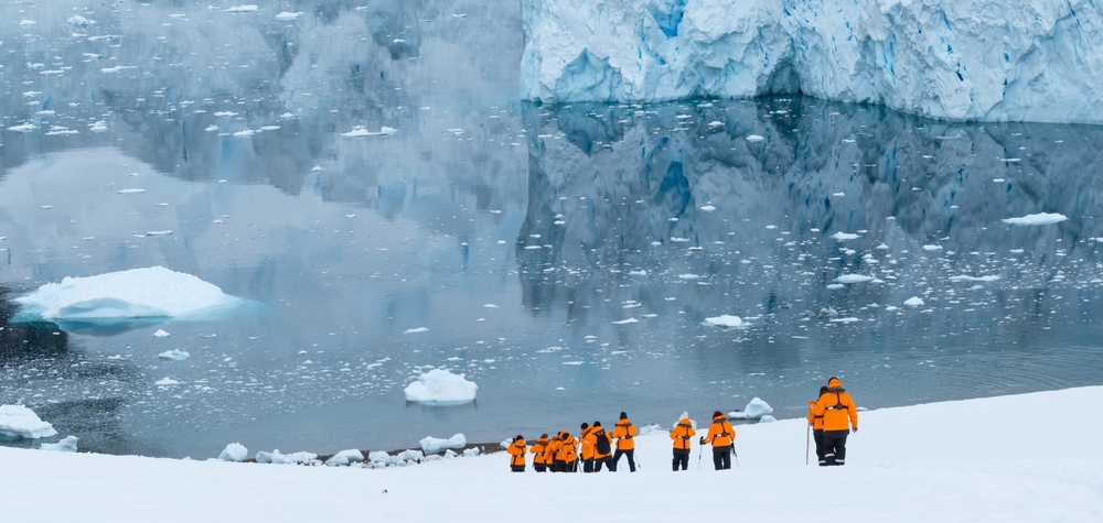 Cruise tourists hiking in the snow during expedition in Antarctica.