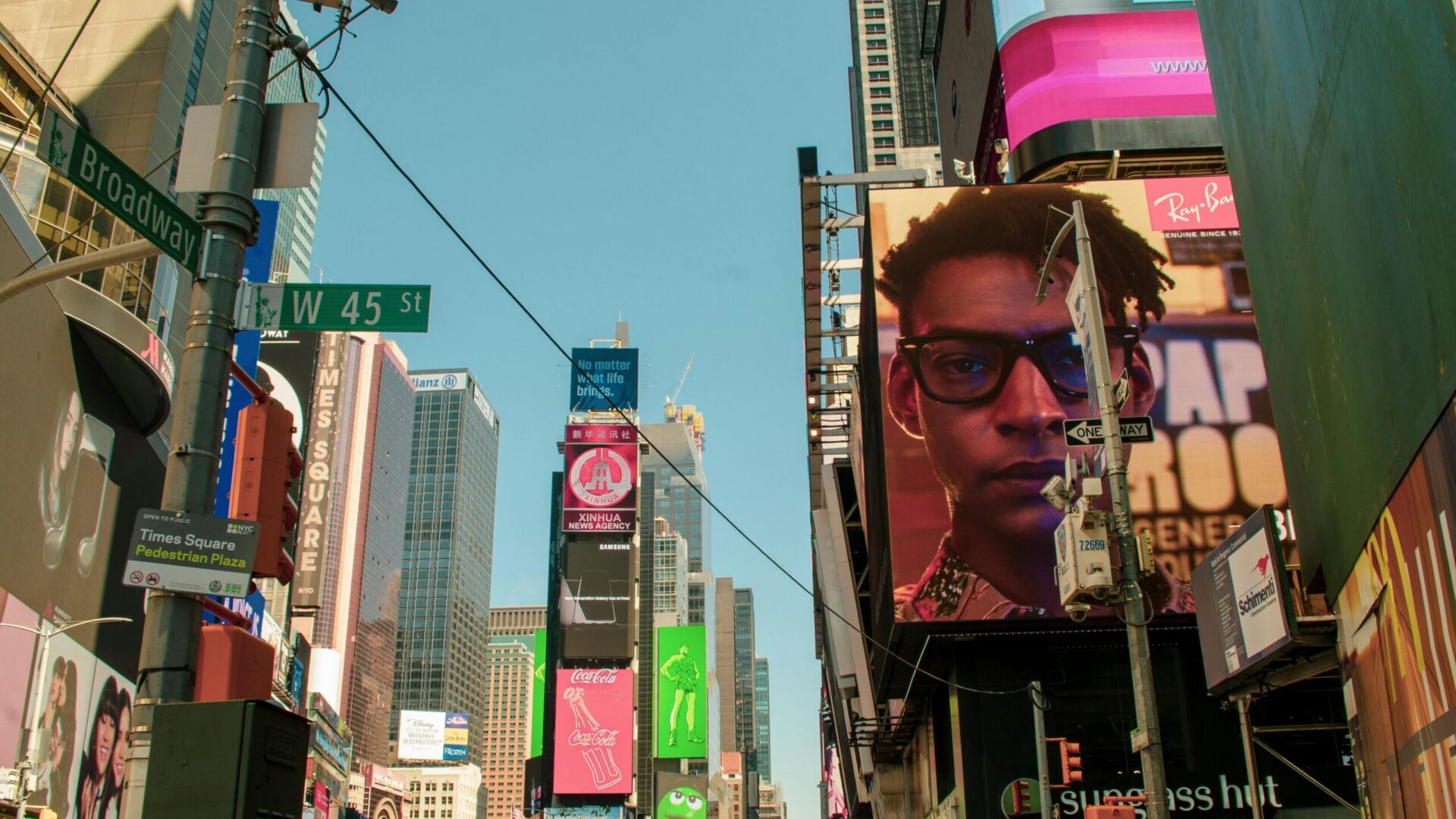 Modern city skyline with tall glass buildings under a clear blue sky.