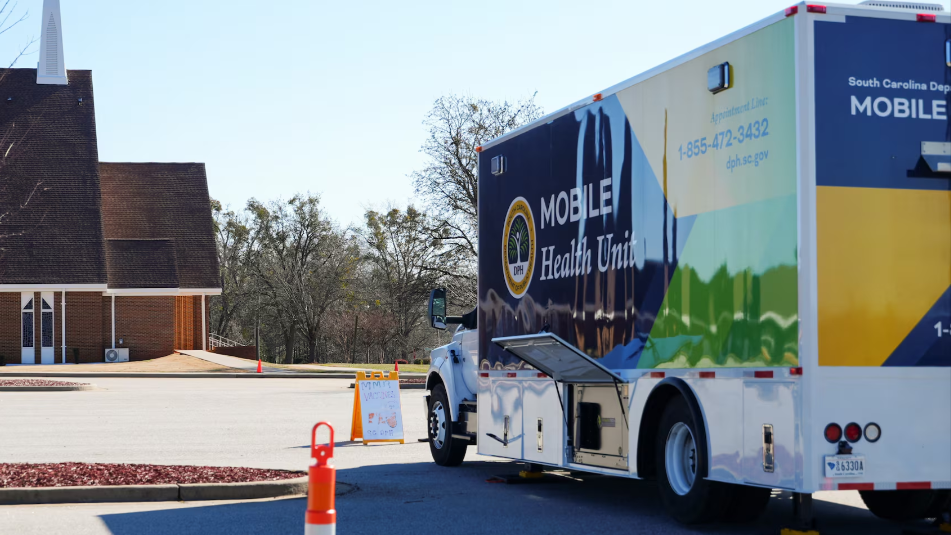 Mobile health unit parked outside a church for vaccinations.